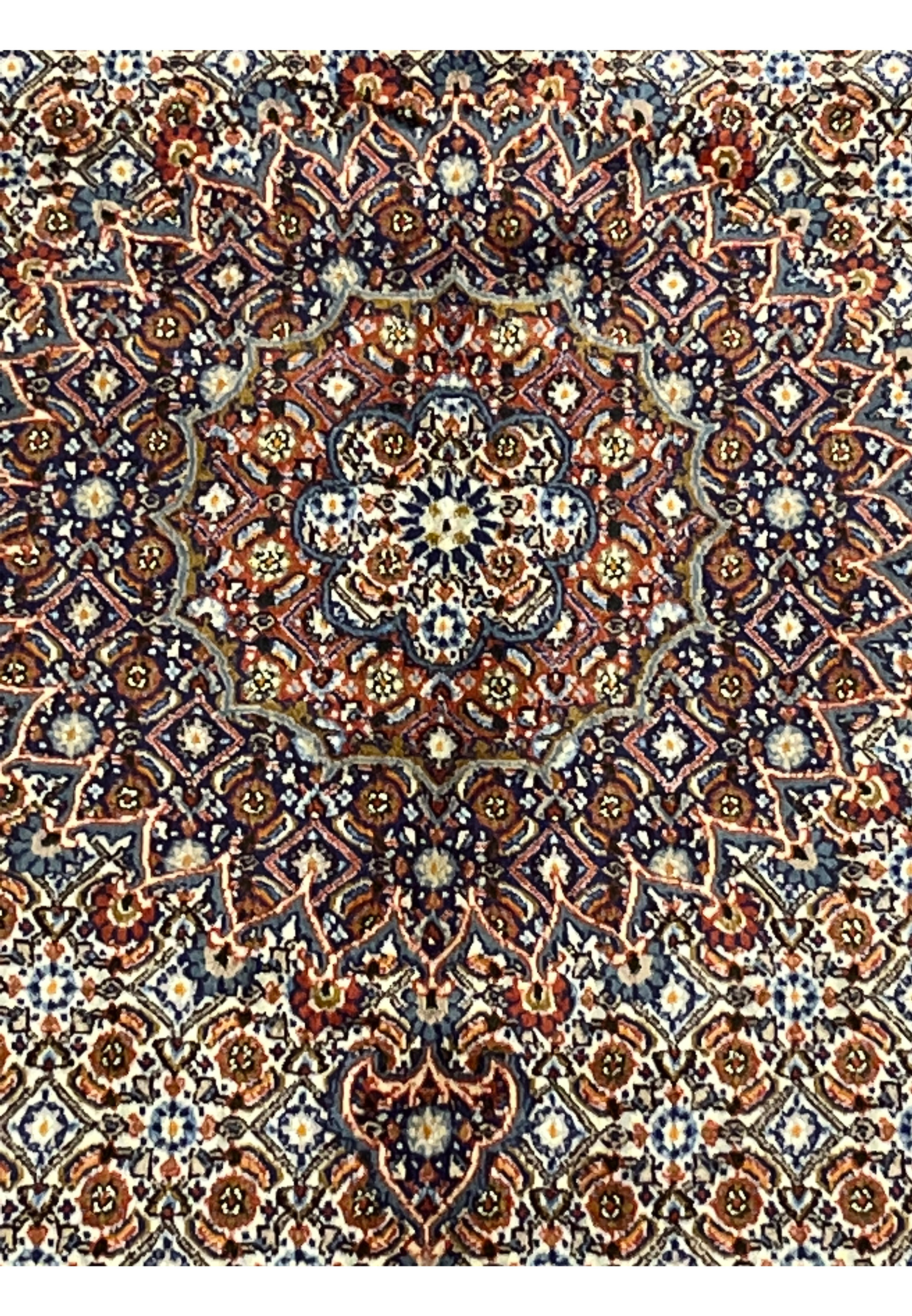 Macro view focusing on the medallion’s floral center, capturing the detailed knotting and interplay of navy, ivory, and terracotta hues typical of authentic Moud craftsmanship.