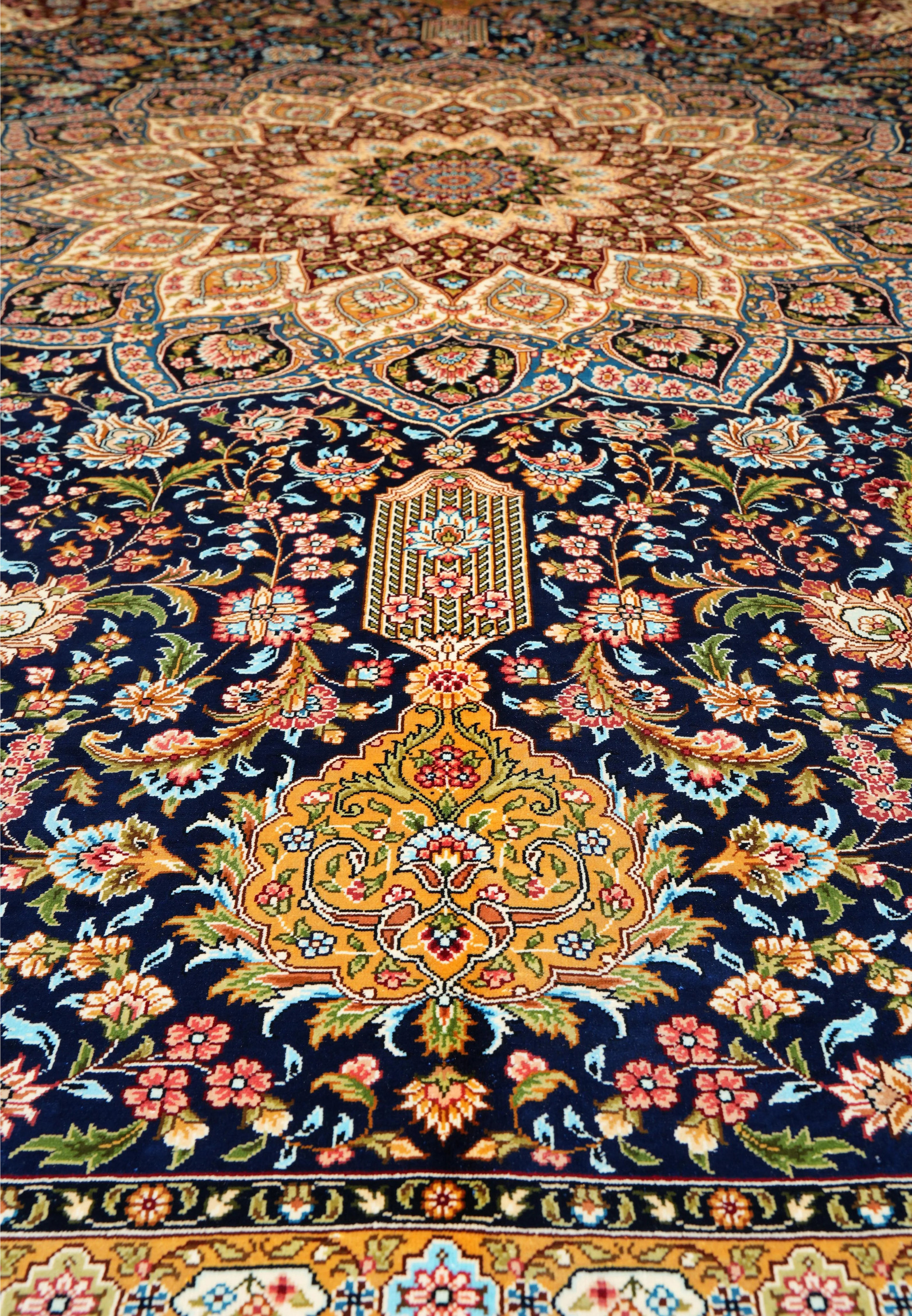 Detailed midfield view showing intricate silk weaving and floral motifs in navy, burgundy, and ivory tones.