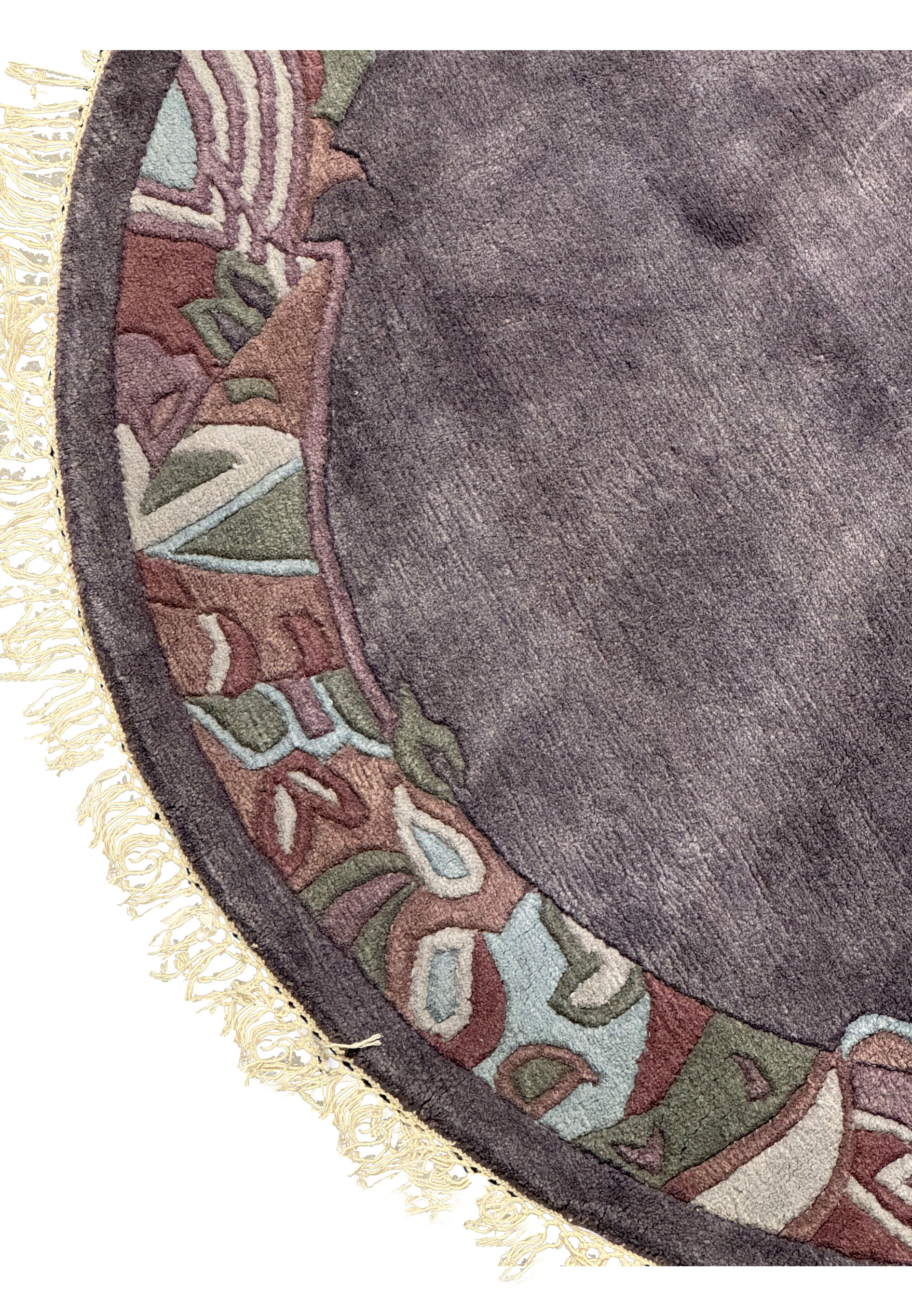 Detailed view of the rug’s edge showing the carved wool texture, light cream fringe, and border design blending earthy tones of olive, mauve, and taupe.