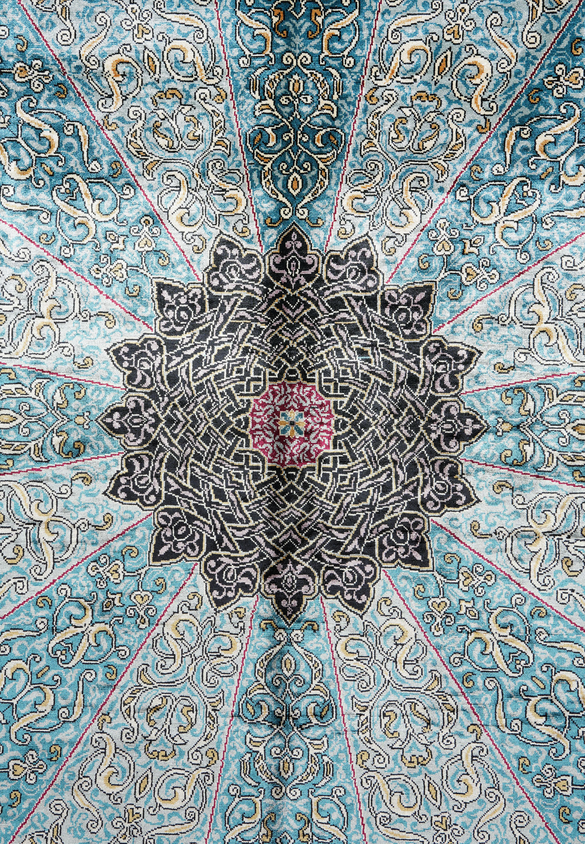 Detailed view of the intricate black and sky-blue medallion of the Chinese silk oriental rug