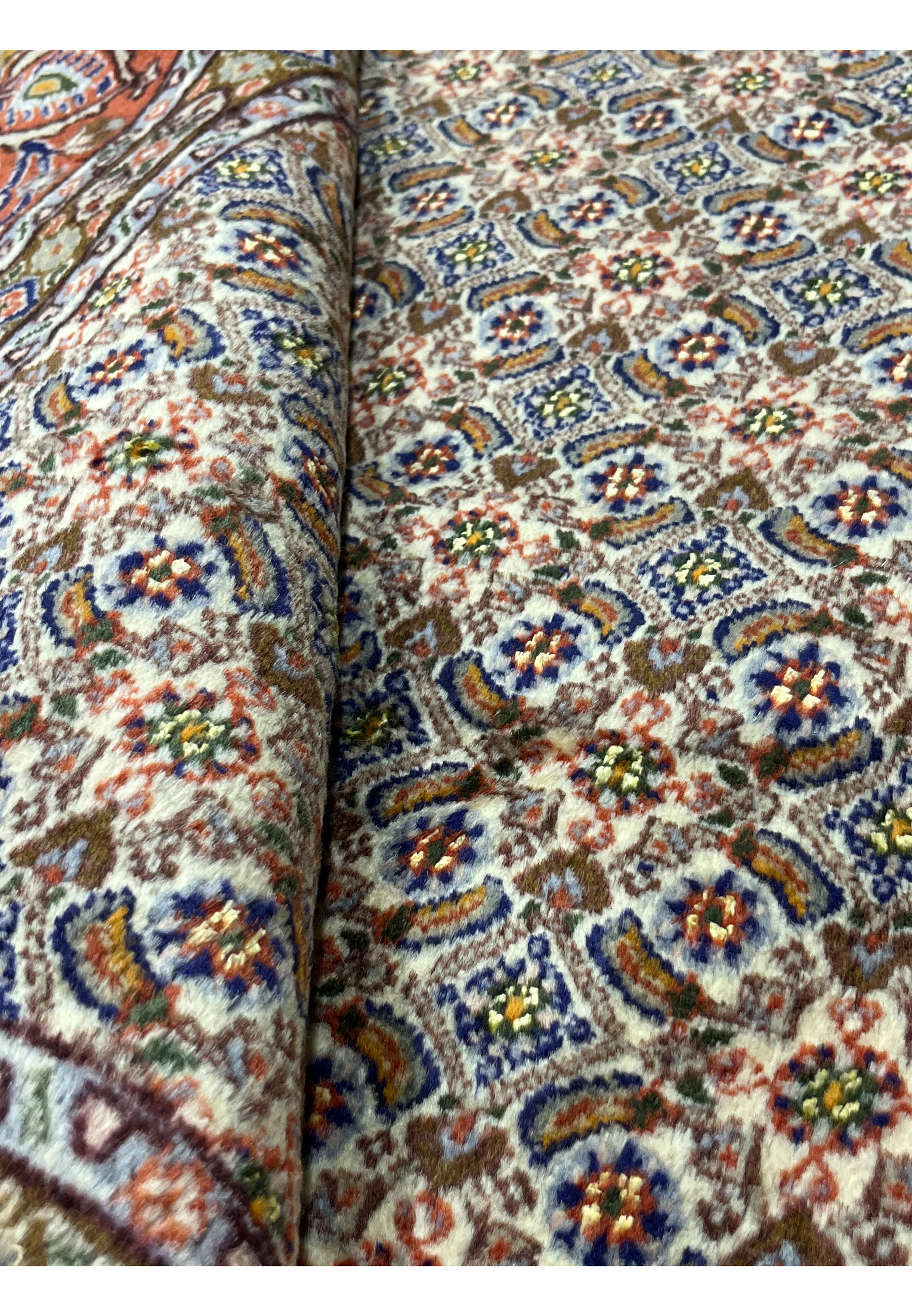 Rolled view of Persian Moud rug showing soft wool pile and elegant handwoven texture.