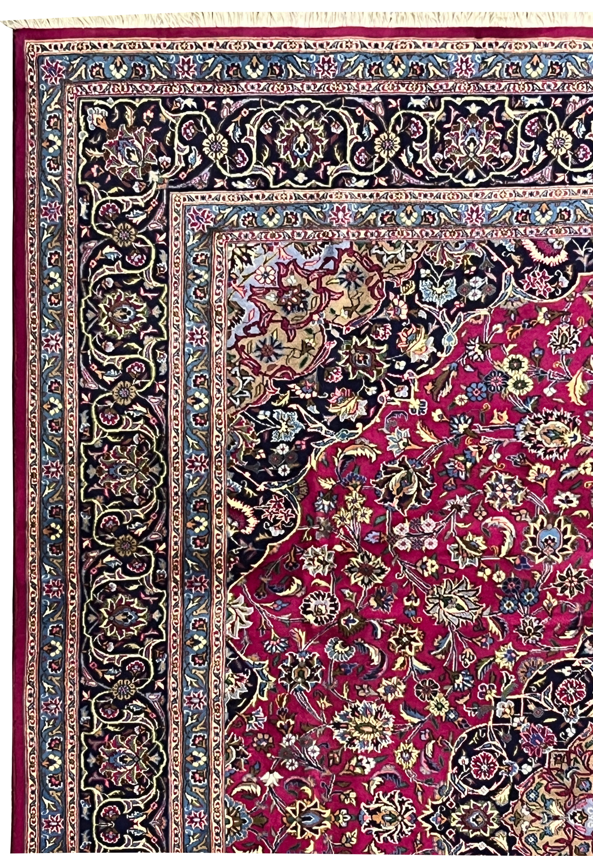 Upper border close-up of Persian Mashad rug with navy vines, sky blue accents, and floral scrolls.