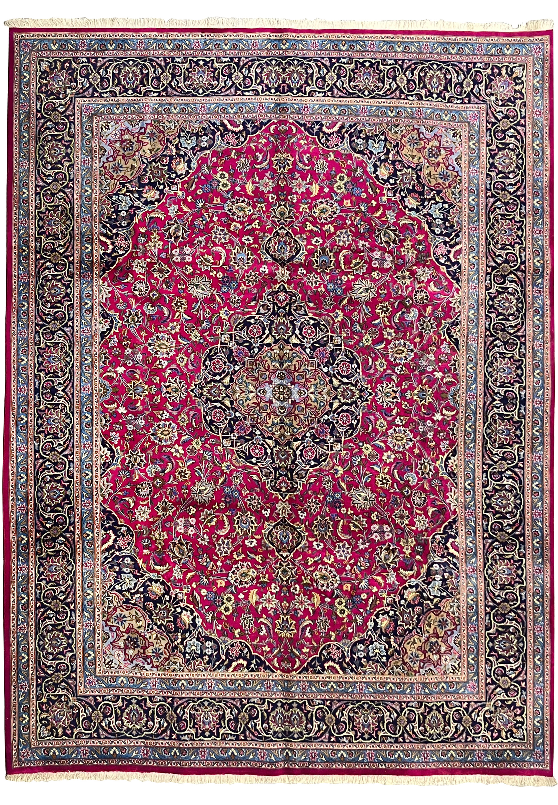 Full laid-down view of 9'9 x 12'8 semi-antique Persian Mashad red wool rug with navy border and central medallion.
