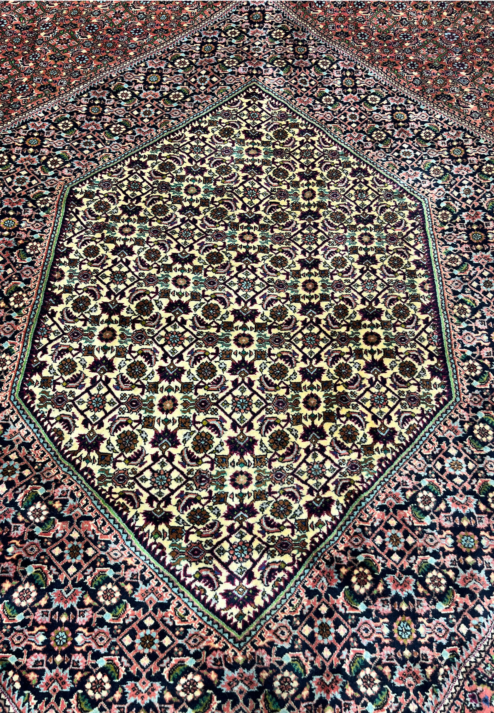 Close-up of the Bijar rug’s central hexagonal medallion with ivory field, dense floral lattice, and dark navy outlines.