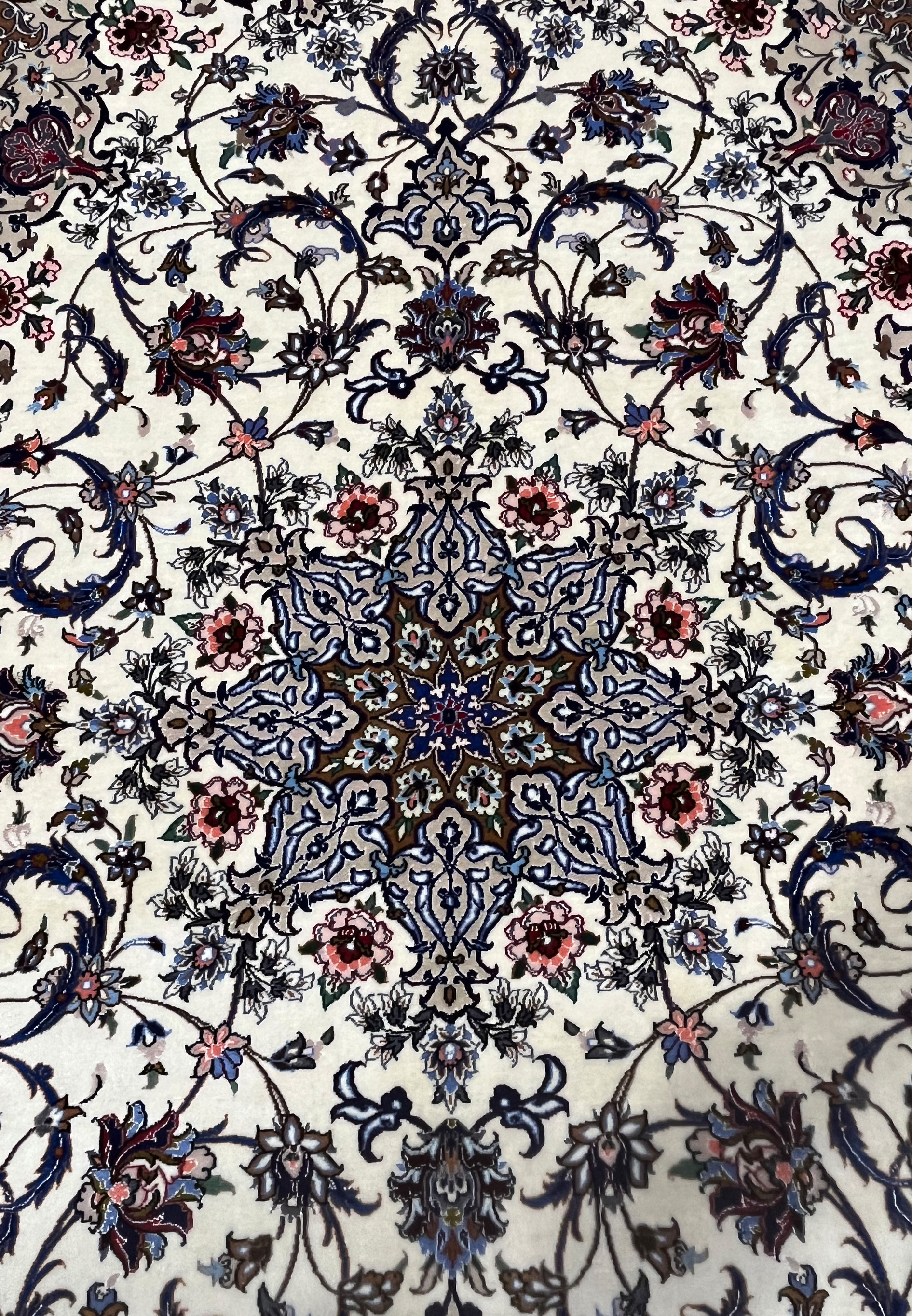 Close-up of the Persian Isfahan medallion featuring navy blue, burgundy, and pink floral details with silk highlights.