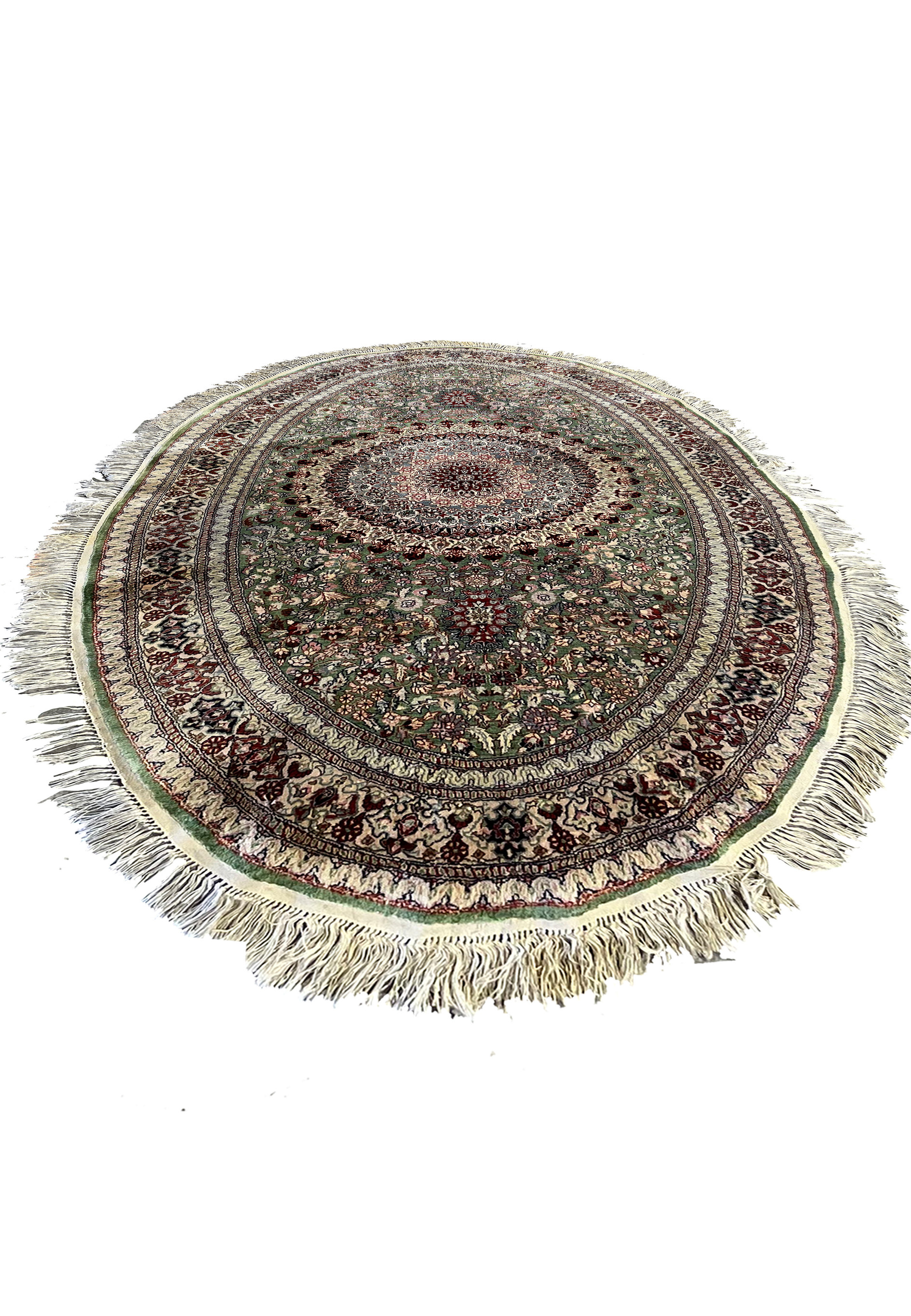 Oval Persian Qum pure silk rug laid flat, showing detailed floral medallion, fine knotting, and shimmering green, ivory, and burgundy tones.