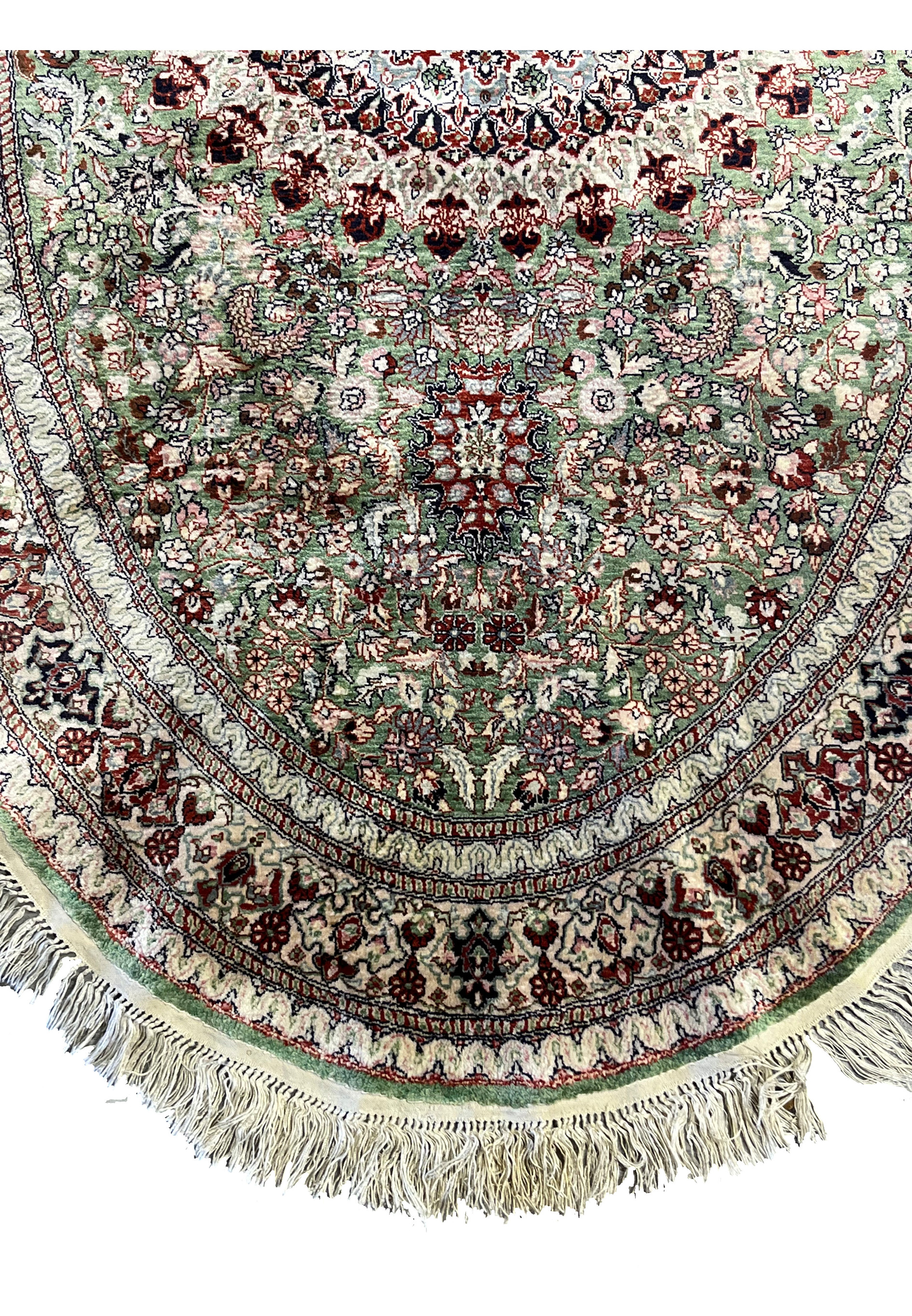 Lower portion of Persian Qum silk rug highlighting intricate green floral motifs, fine borders, and precise knot craftsmanship.