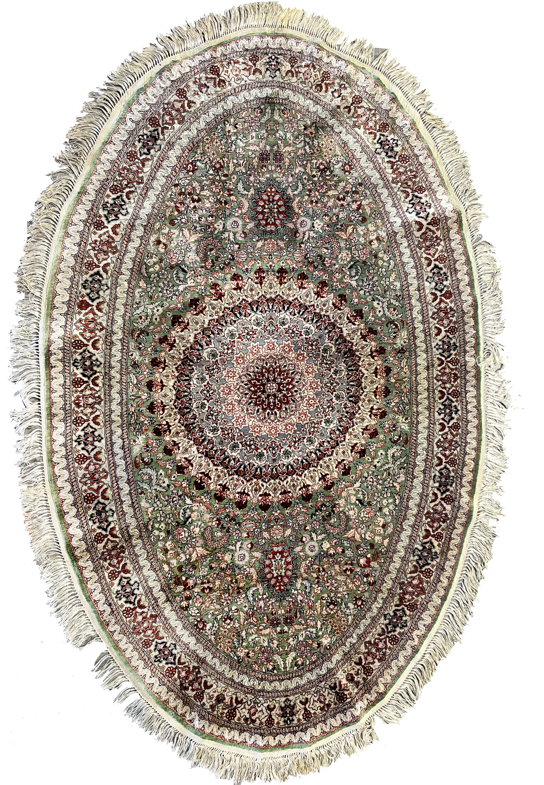 Full oval view of Persian Qum pure silk rug with dense 600 KPSI floral design, central medallion, and rich green, red, and ivory detailing.