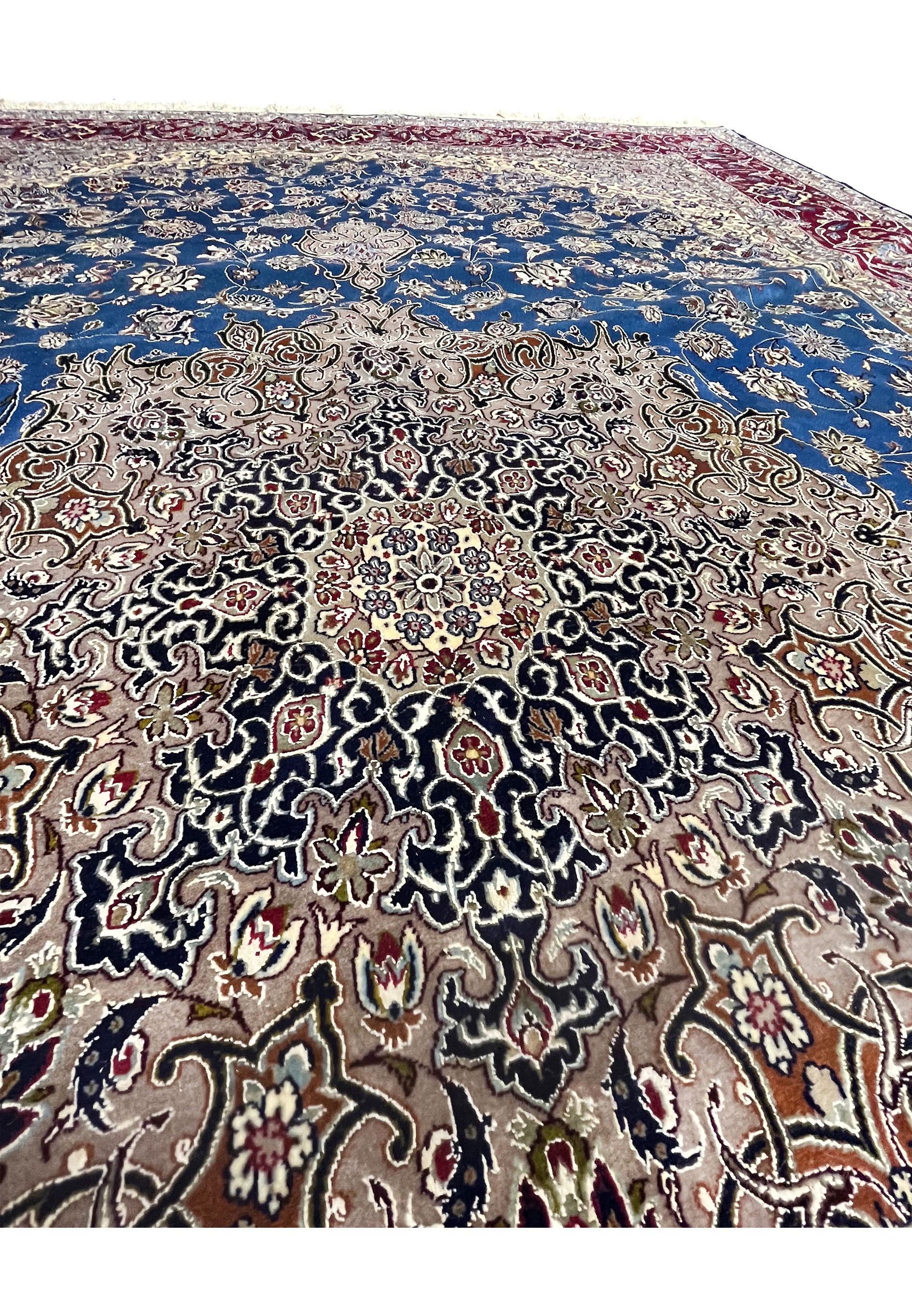Close-up of the ornate central medallion with layered beige, navy, and red floral motifs on the fine wool-and-silk Isfahan rug.