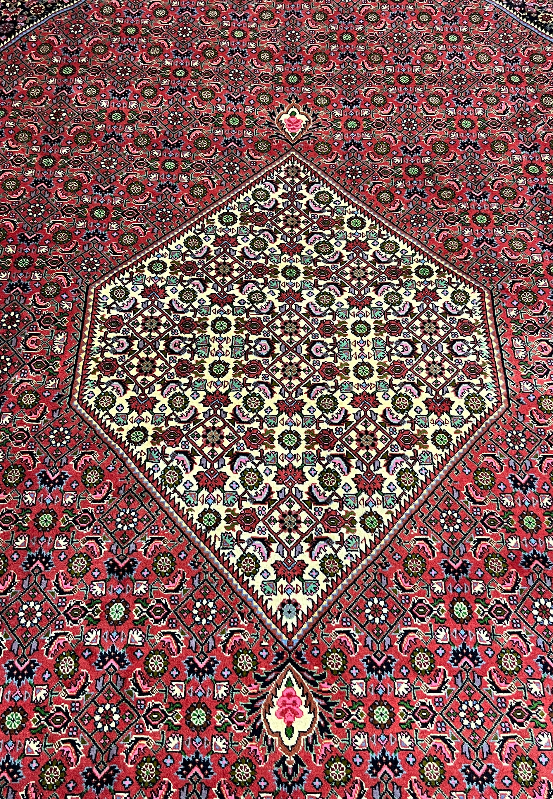 Central ivory diamond medallion on Persian Bijar iron rug filled with micro floral motifs over rich crimson and dark navy background