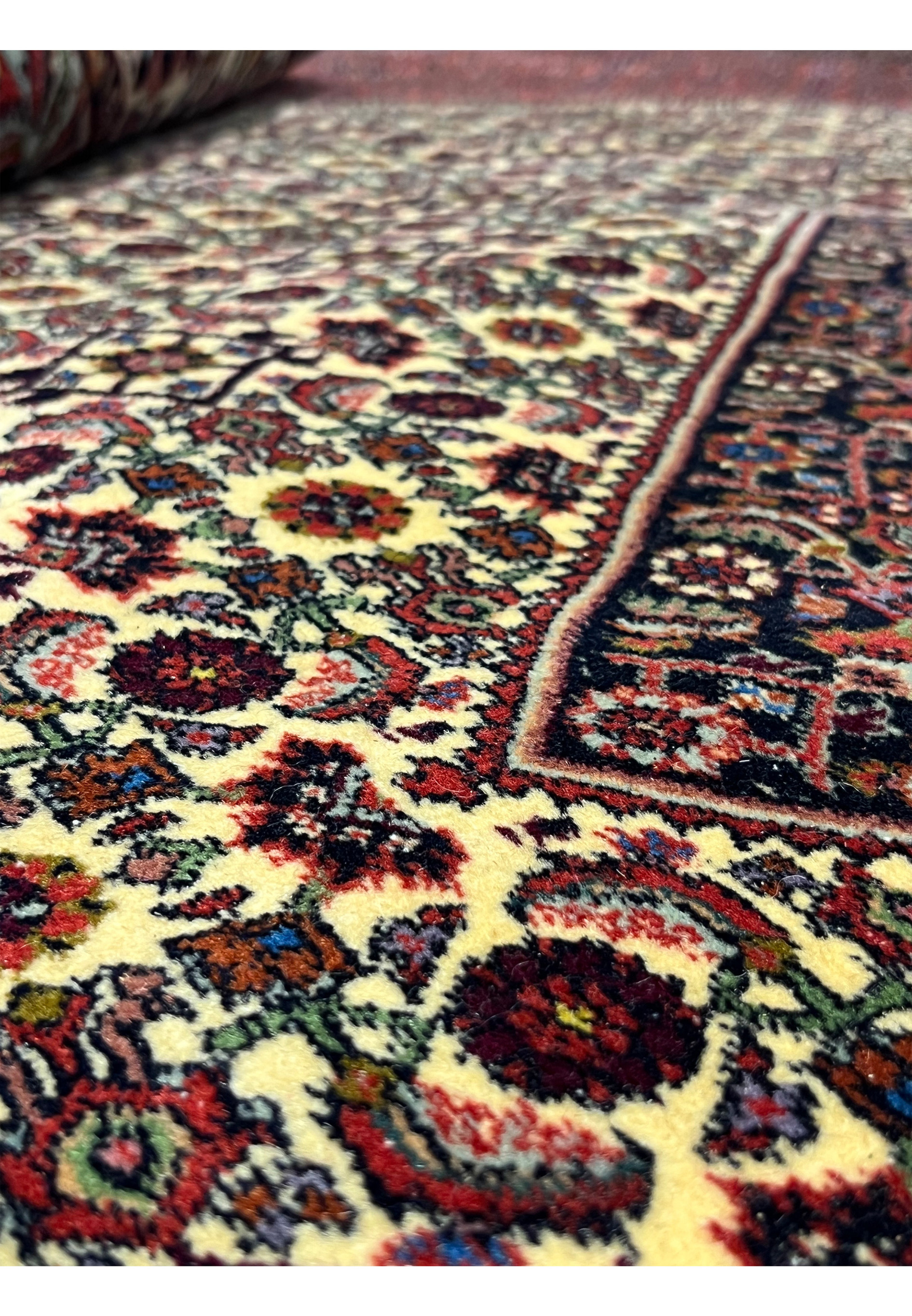 Close up of red and navy geometric pattern on handmade 10x13 Persian Bijar wool rug