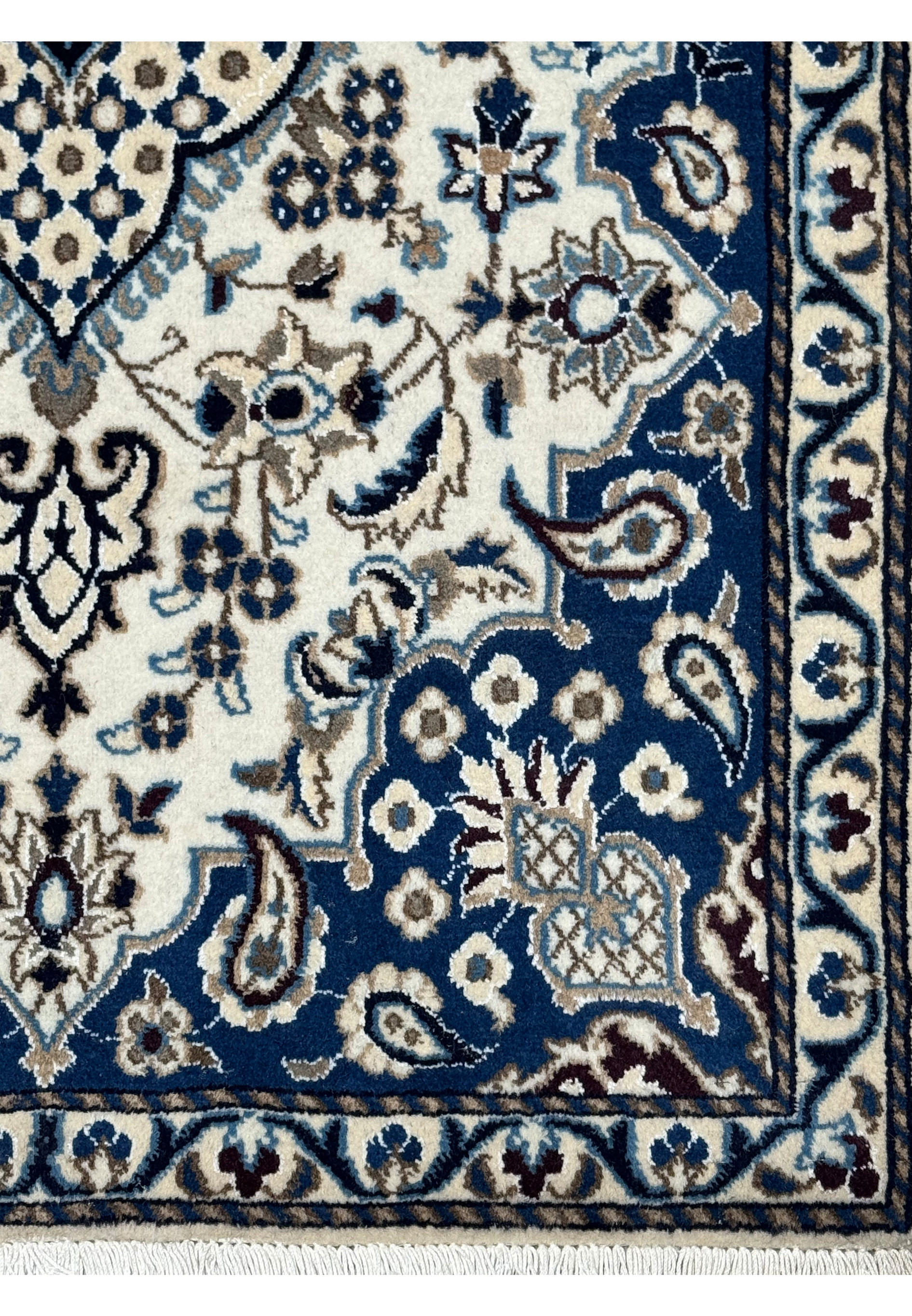 Border detail of Persian Nain rug with royal navy blue background, ivory floral motifs, powder blue accents, and scrolling vine patterns
