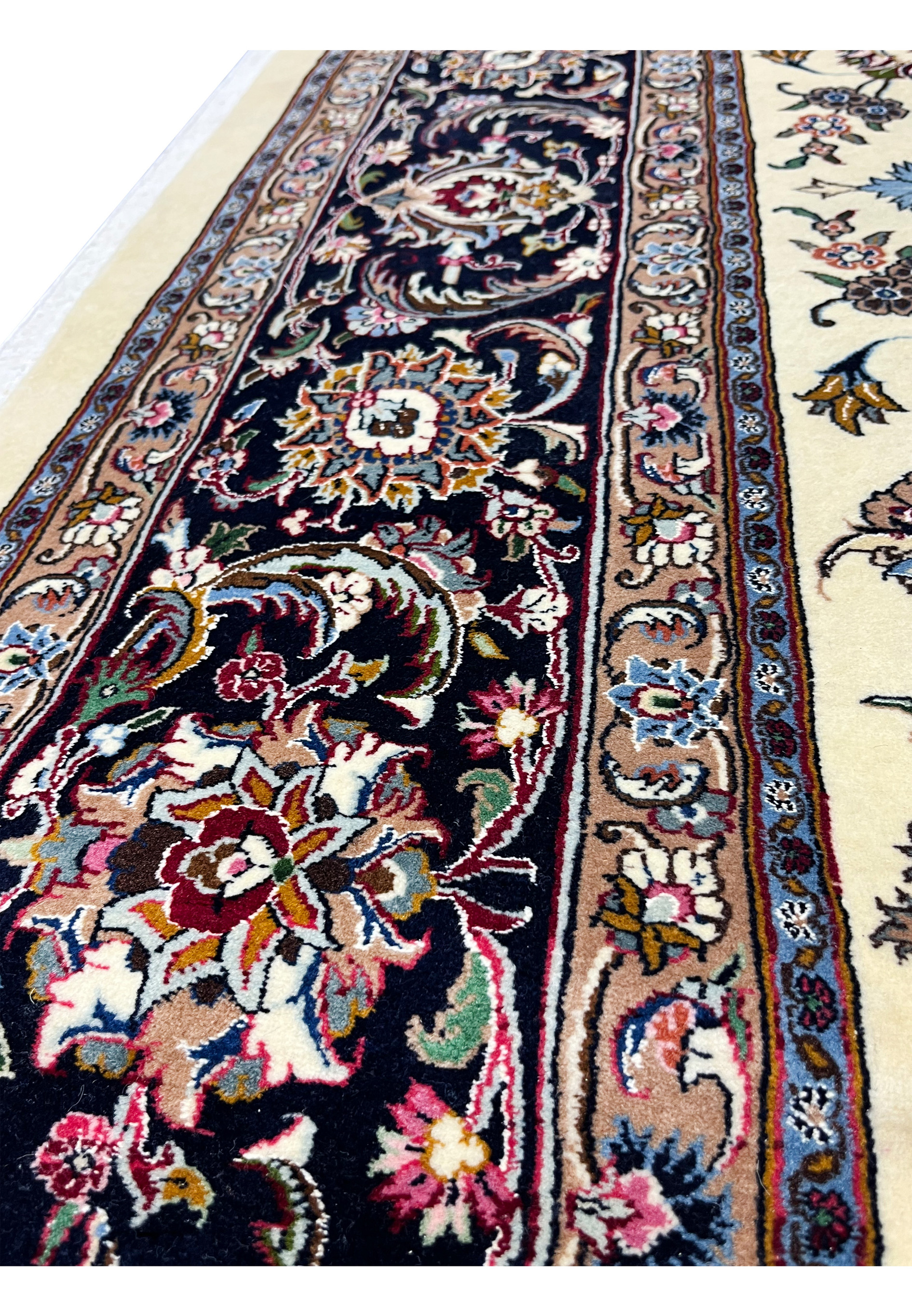 Close-up of intricate border flowers on signed Mashad Saber rug
