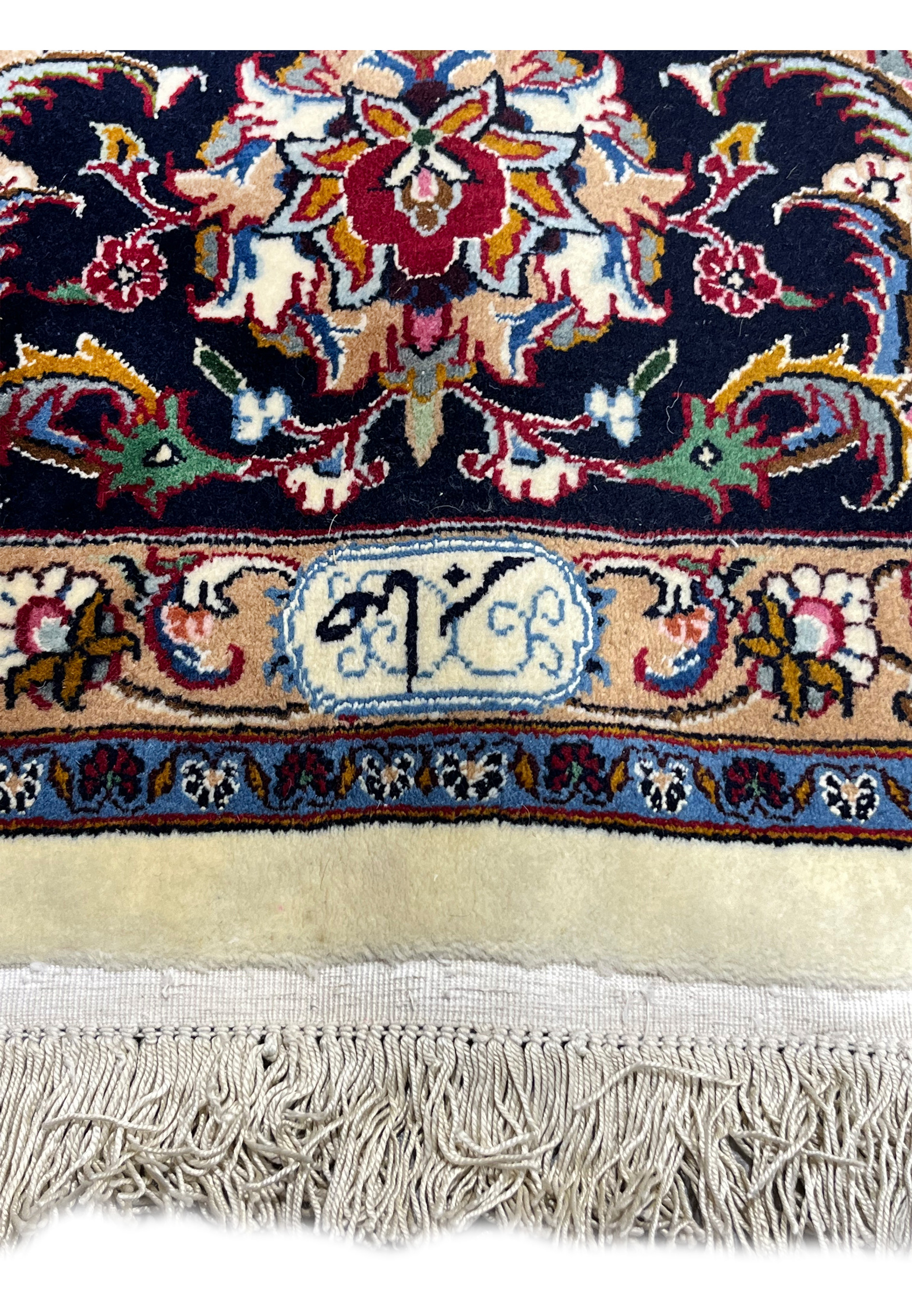 Close-up of woven Saber signature on signed Persian Mashad rug located in the lower border above the fringe