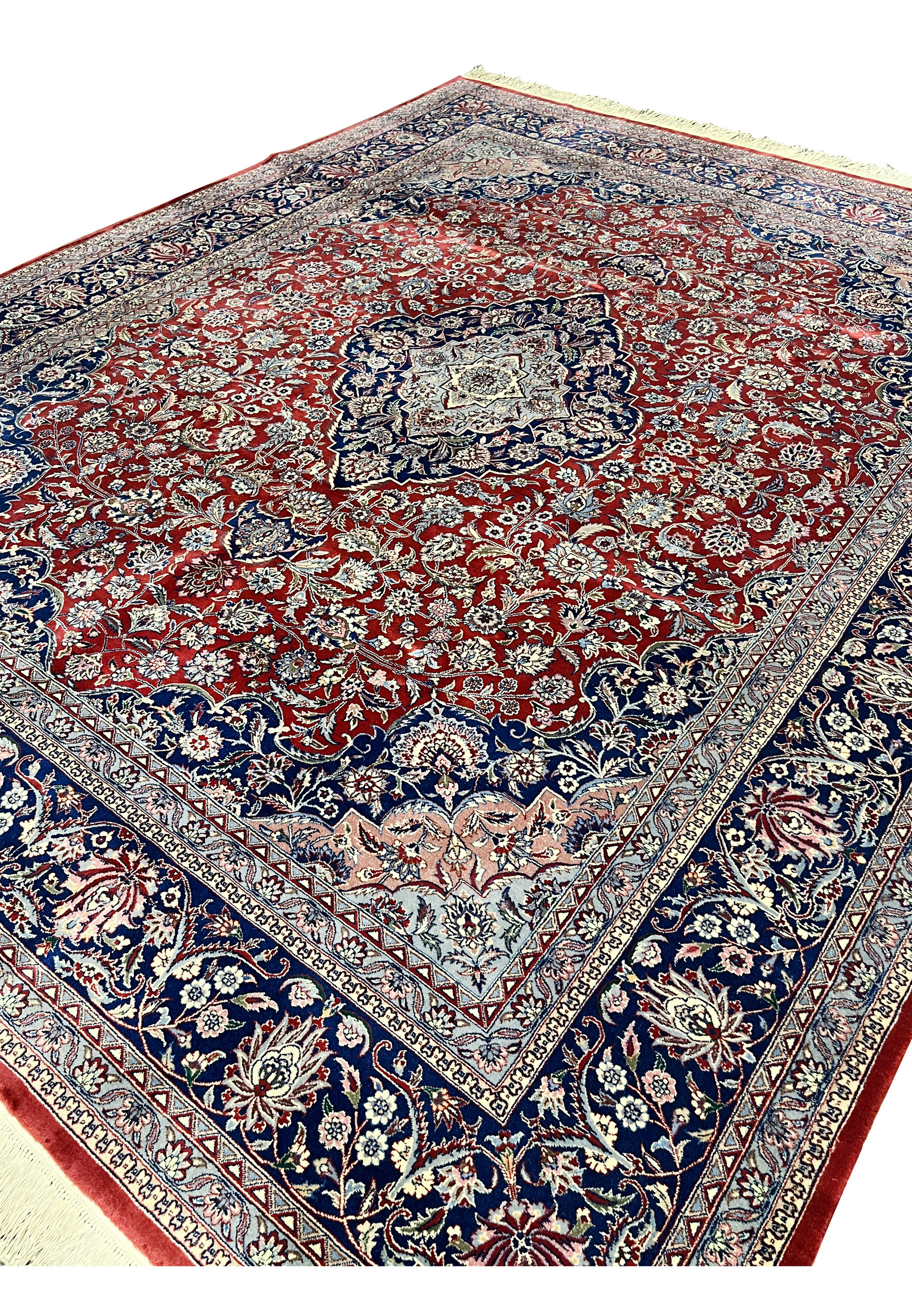 Angled overview of Persian Kashan rug emphasizing medallion layout