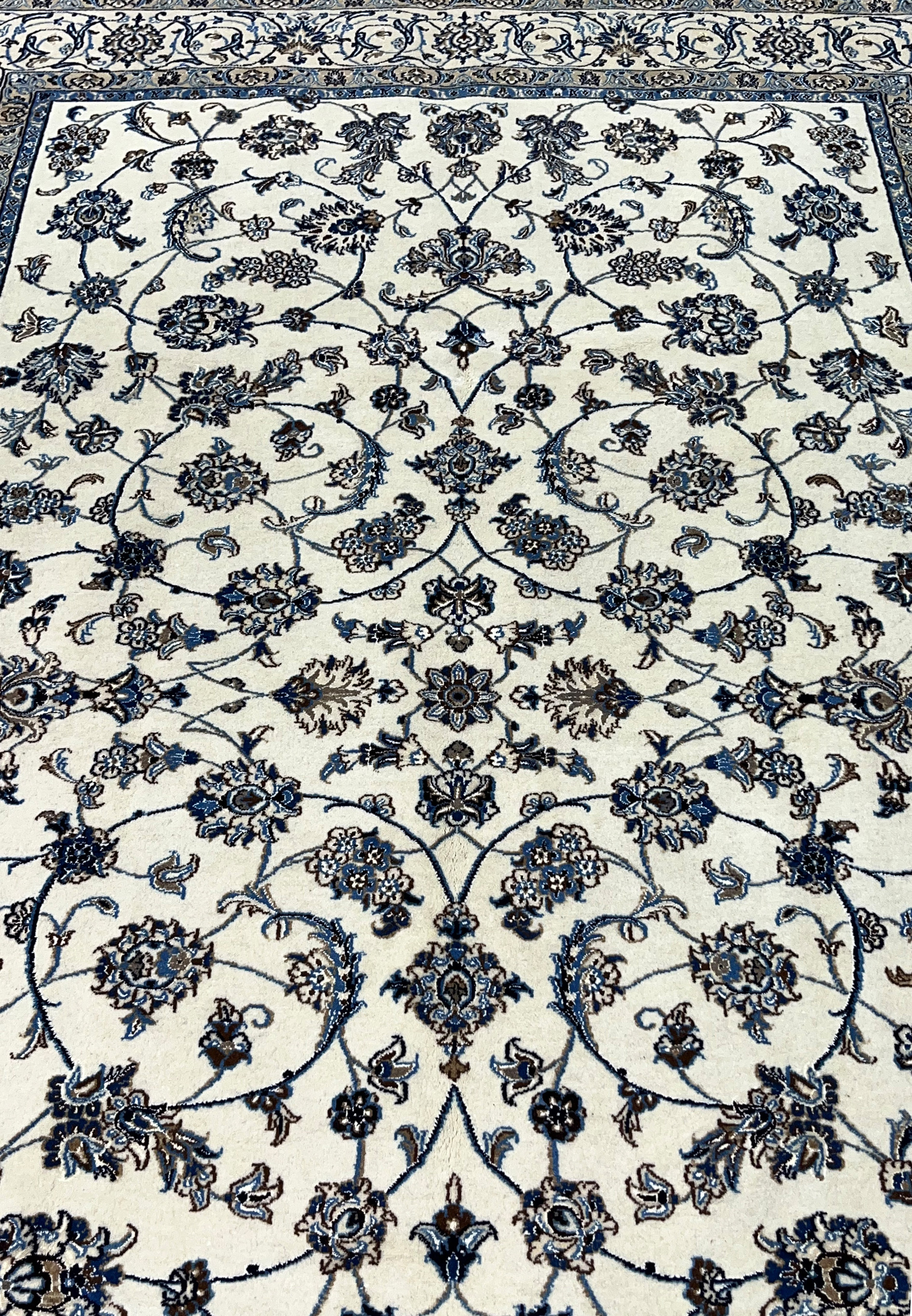 Midfield closeup of Persian Nain rug showing silk highlighted floral rosettes