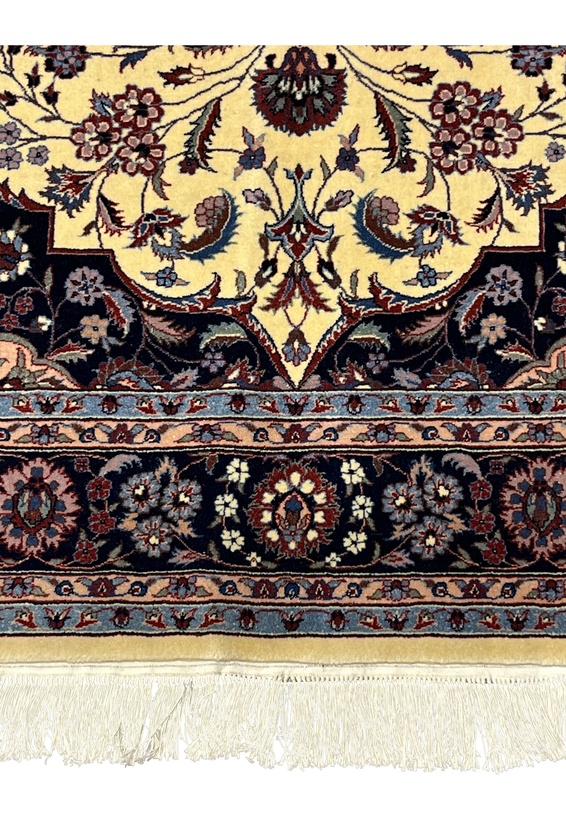 Lower border detail of Persian Tabriz rug with repeating floral rosettes on navy groun