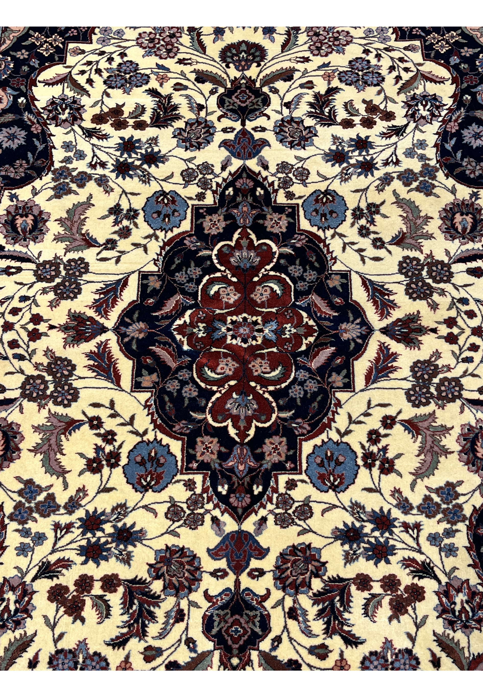 Persian Tabriz rug central medallion with layered floral motifs in navy, burgundy, and steel blue on an ivory background