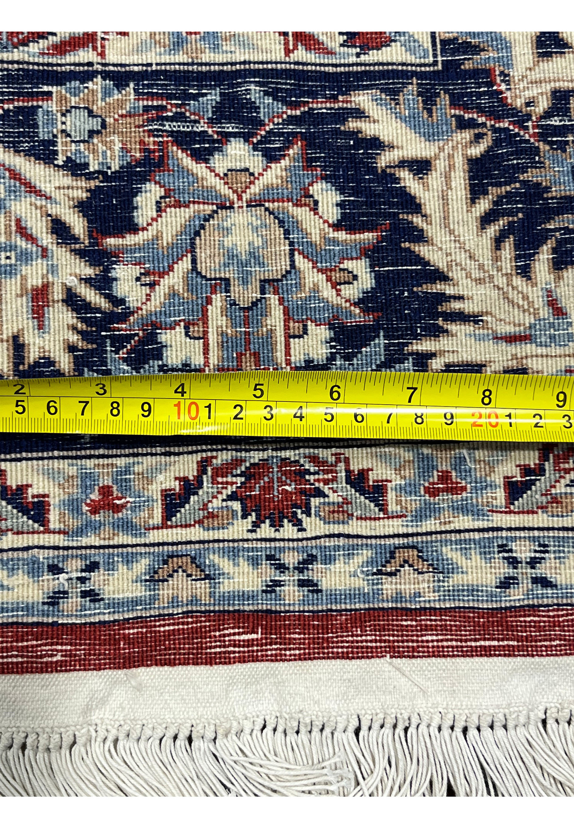 Backside of 5'6 x 8 Persian Tabriz rug with ruler showing tight knot density, straight weave, and precise width measurement
