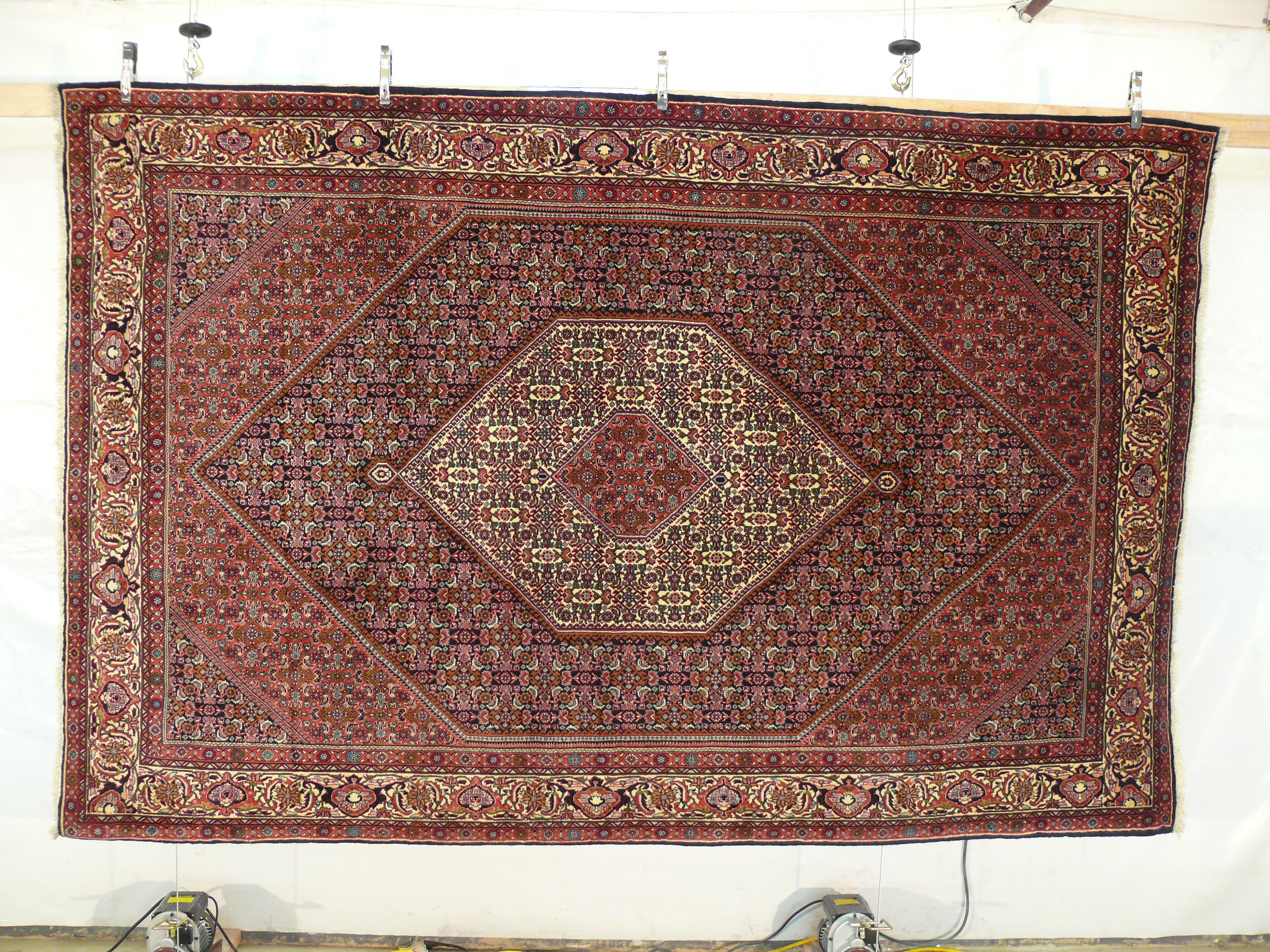 Persian Bijar iron rug hanging display showing dense weave and geometric medallion design