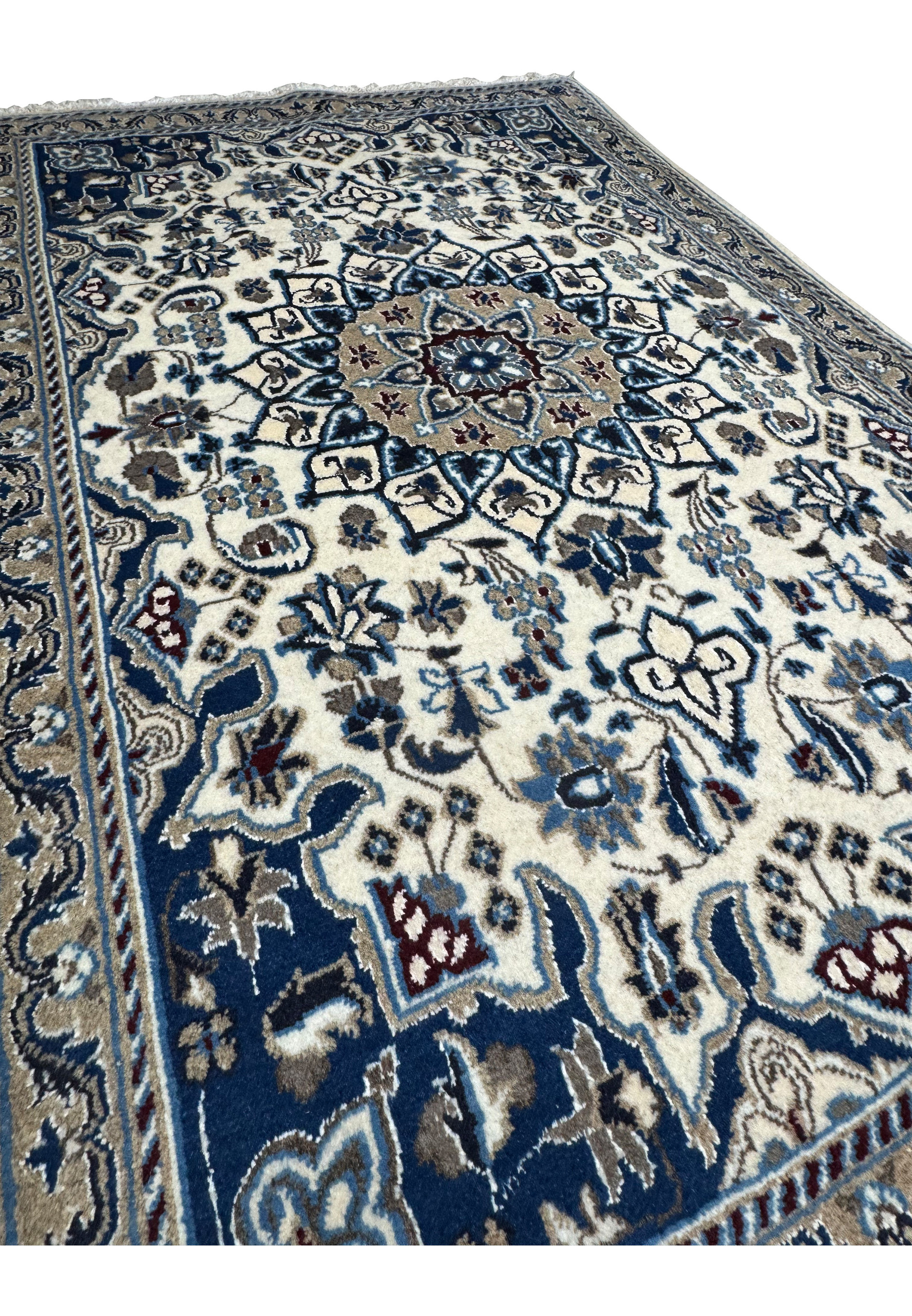 Angled perspective highlighting wool pile texture and detailed medallion of Persian Nain rug