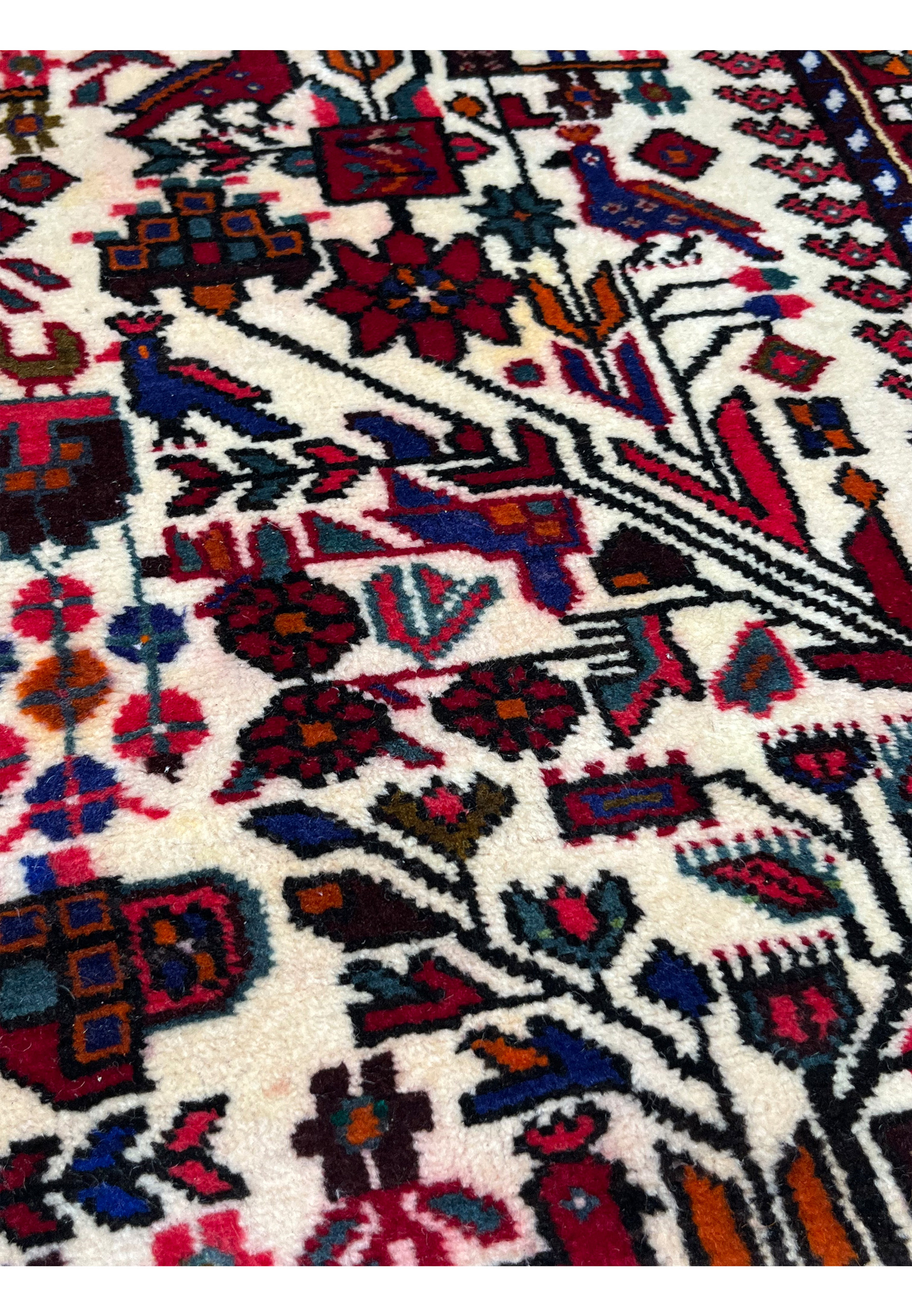 Detailed view of tree and bird pattern in Persian Rudbar rug with crisp outlines, balanced tribal geometry, and rich natural wool colors.