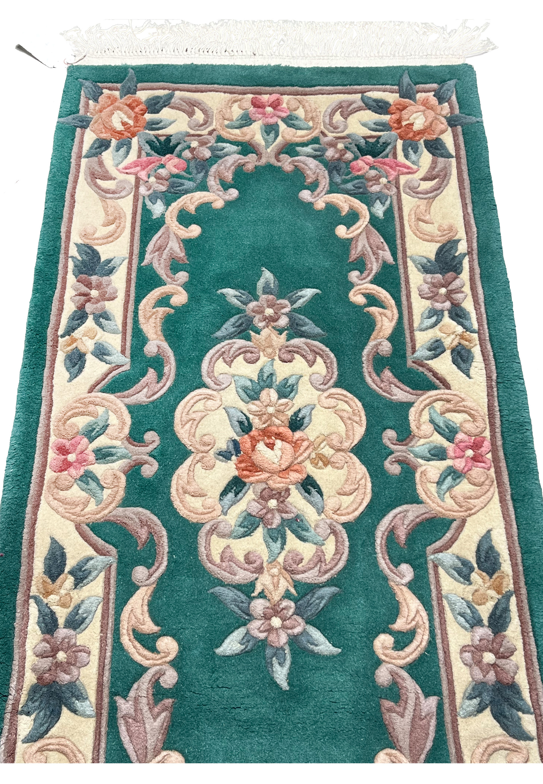 Detailed midfield image of emerald green Aubusson rug emphasizing sculpted floral vines and dimensional Art Deco decorative elements
