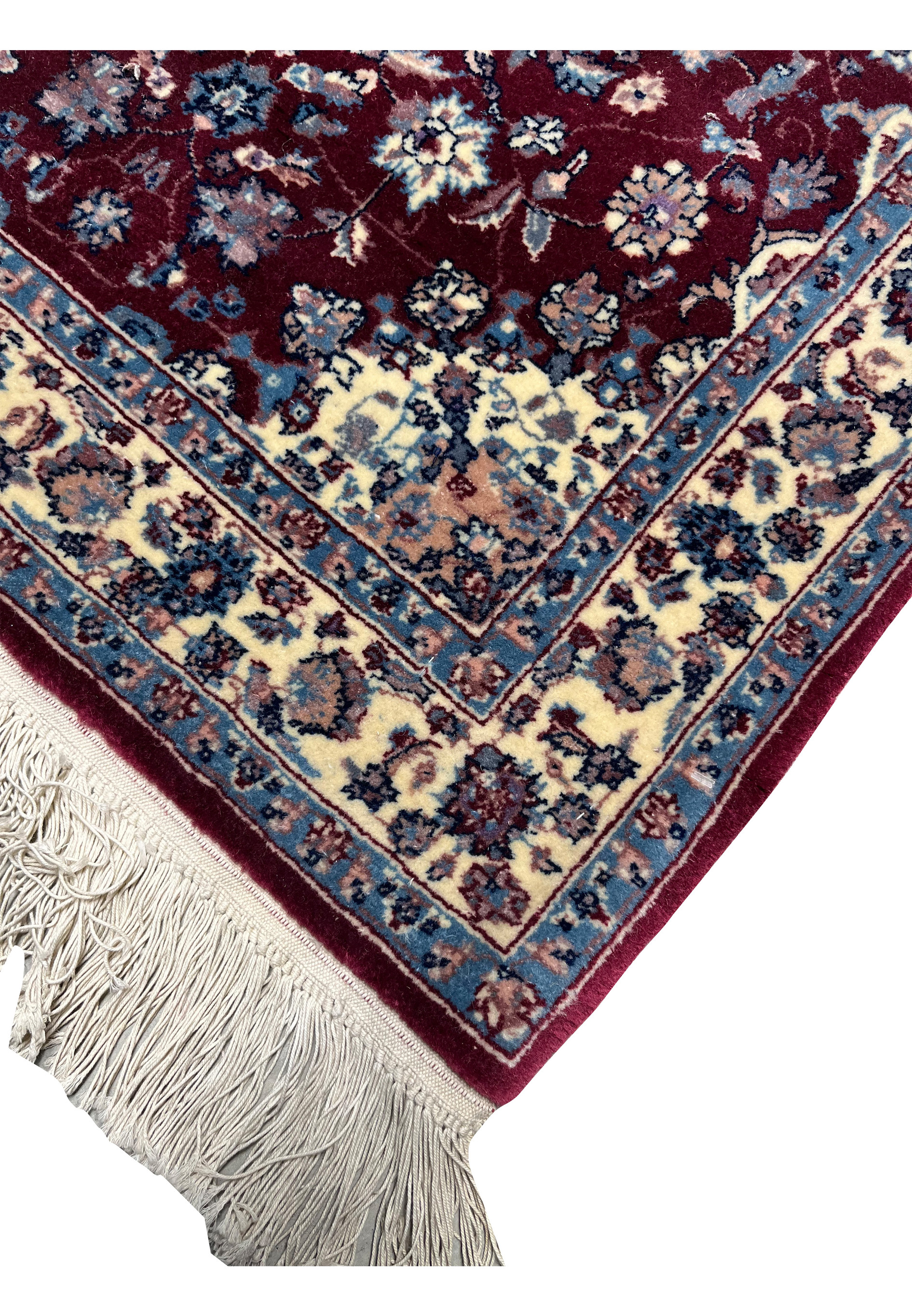 Edge view of a Persian Tabriz rug showing even finishing, crisp borders, tight weave structure, and consistent color definition along the rug perimeter