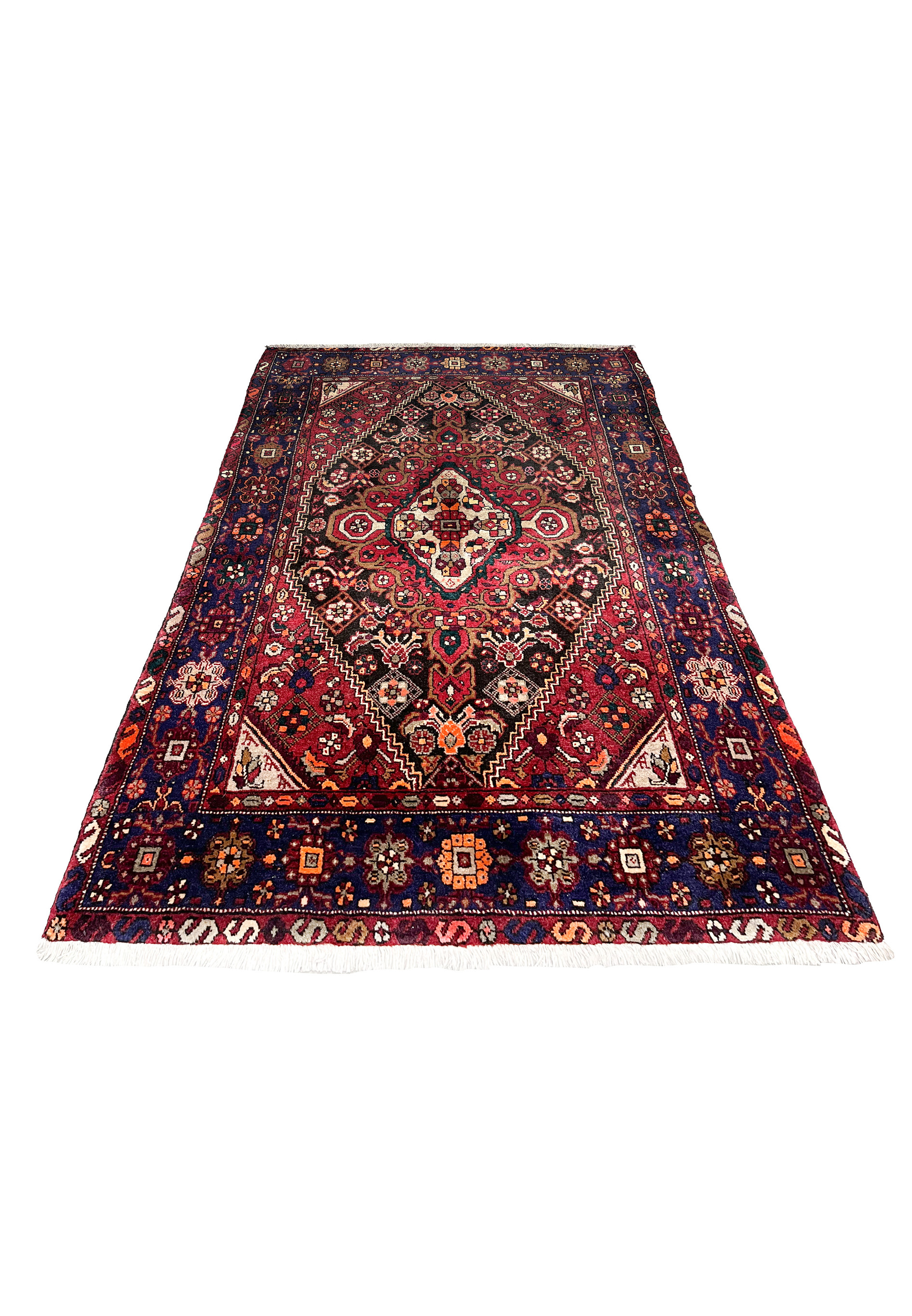 Laid flat view of a Persian Gholtogh rug showing strong geometric medallion, deep red ground, navy framing, and expressive tribal patterning