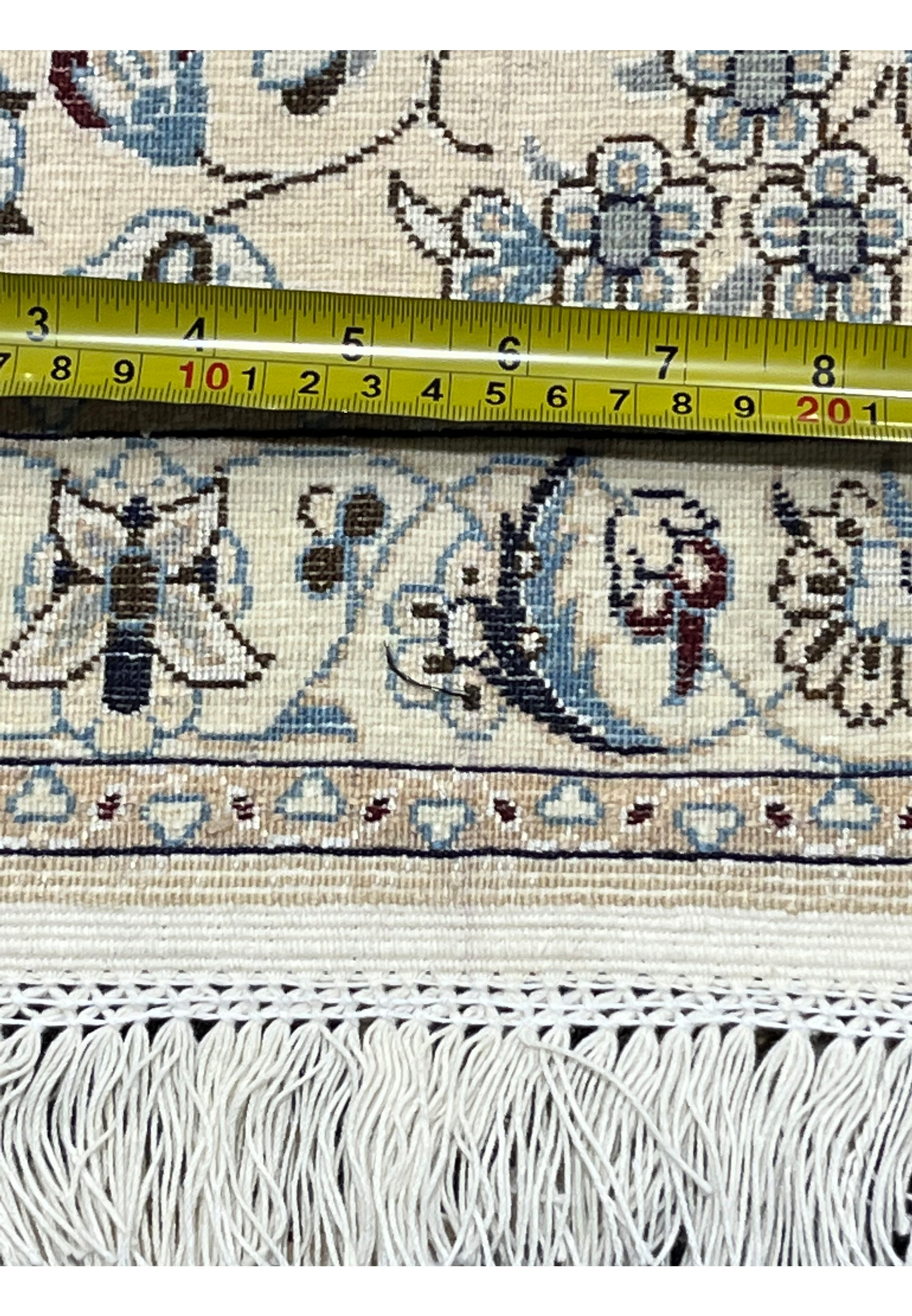 Detailed backside view of a 7x10 Persian Nain 6LA Habibian rug with ruler for scale, highlighting knot consistency, silk and wool foundation, and refined hand-knotting