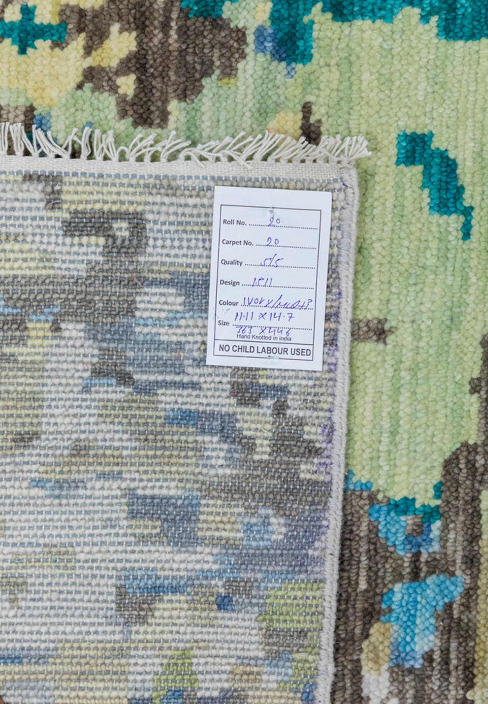 Detailed backside close-up of the rug showing fine knot density, even weaving, and the abstract color pattern visible through the wool foundation.