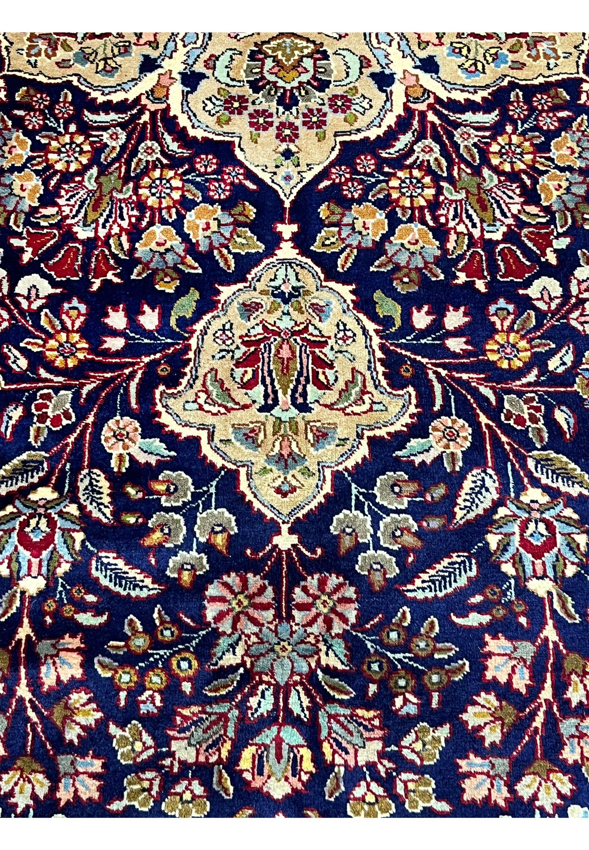 Floral motif close up on Persian Tabriz rug showing navy blue background, ivory outlines, burgundy flowers, and precise craftsmanship