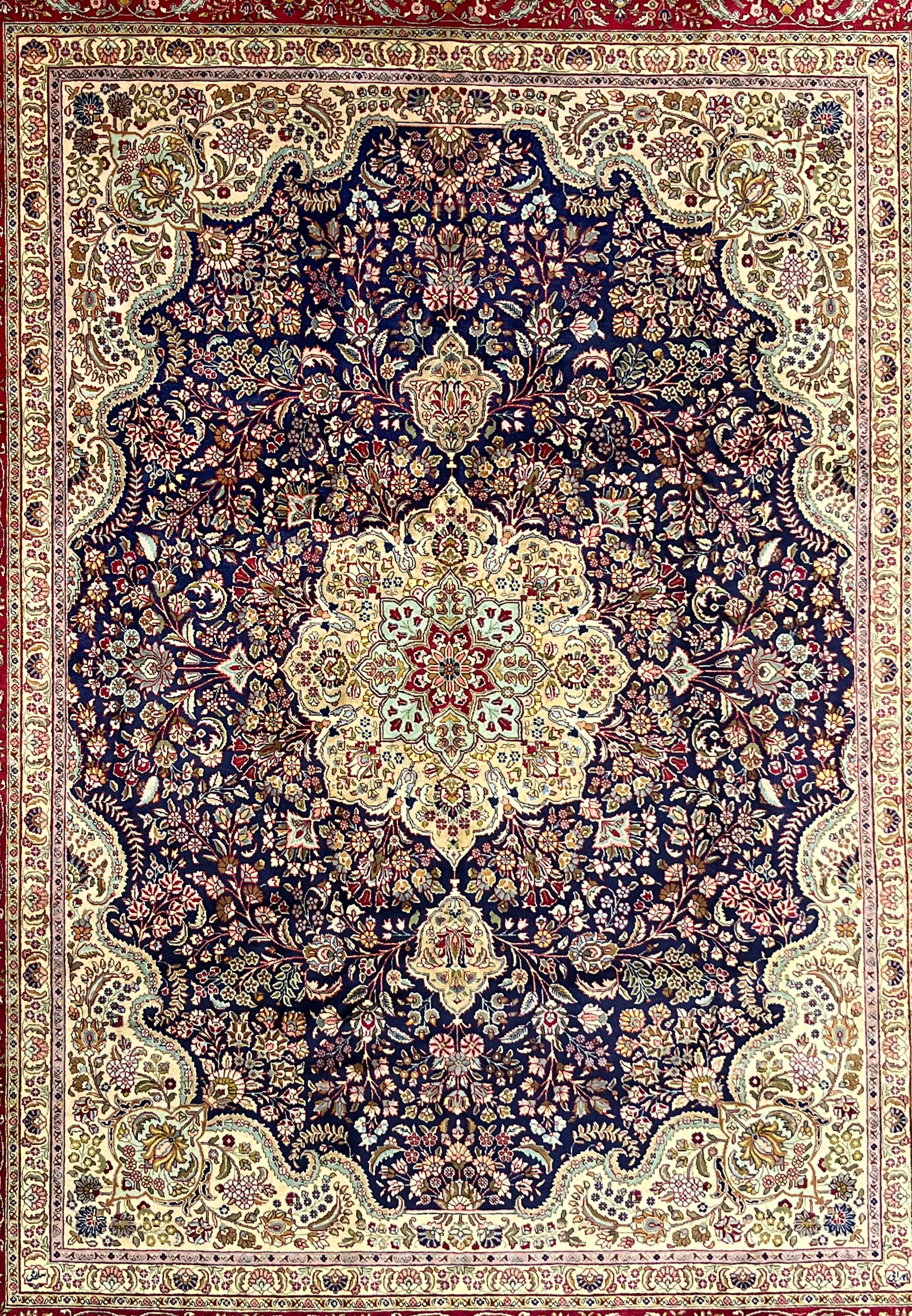Close view of Persian Tabriz rug midfield with deep navy background, layered floral motifs, fine knotting, and rich color contrast