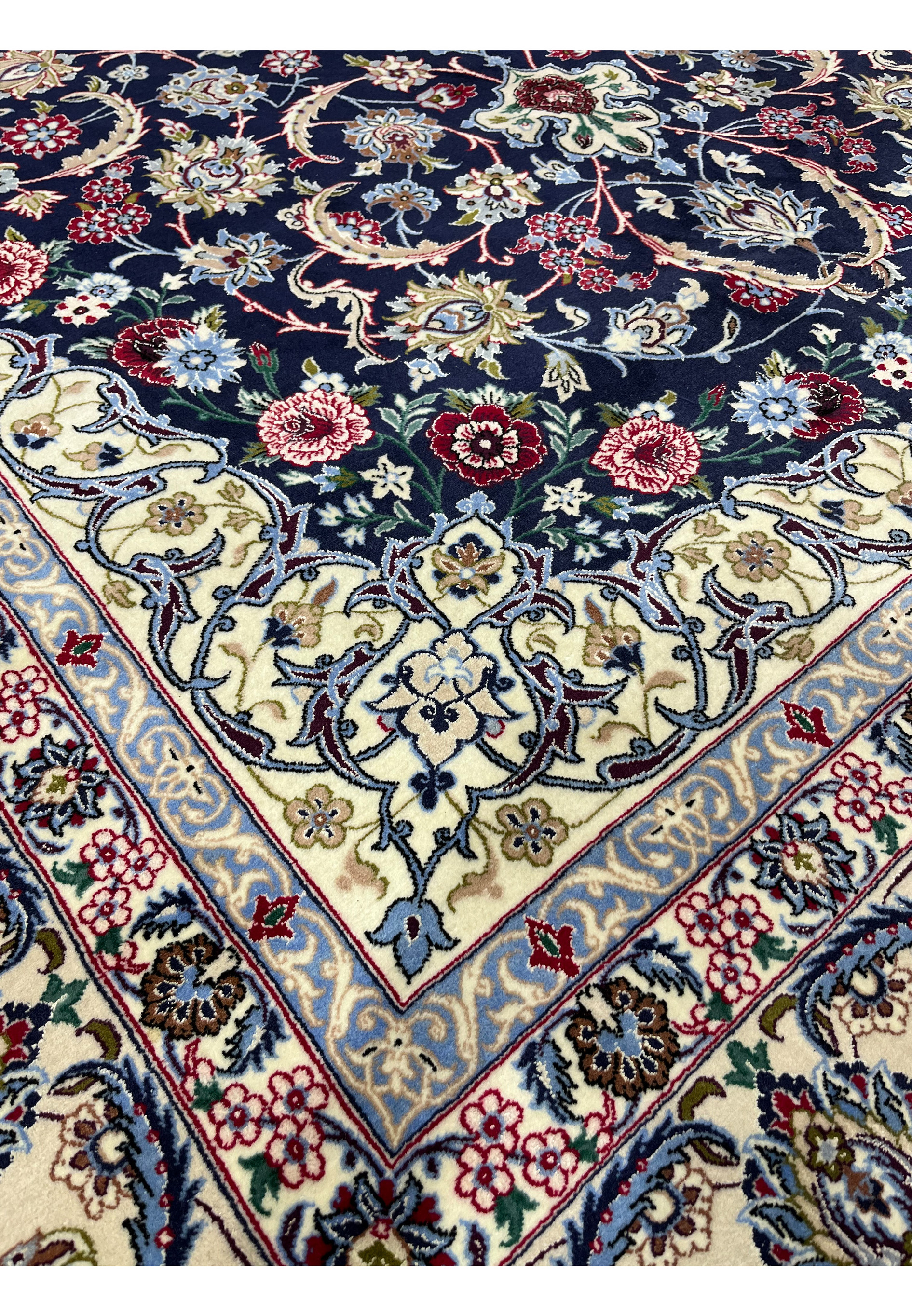 Inner border detail of a Persian Isfahan rug with delicate floral scrolls in powder blue, ivory, burgundy red, and muted green tones