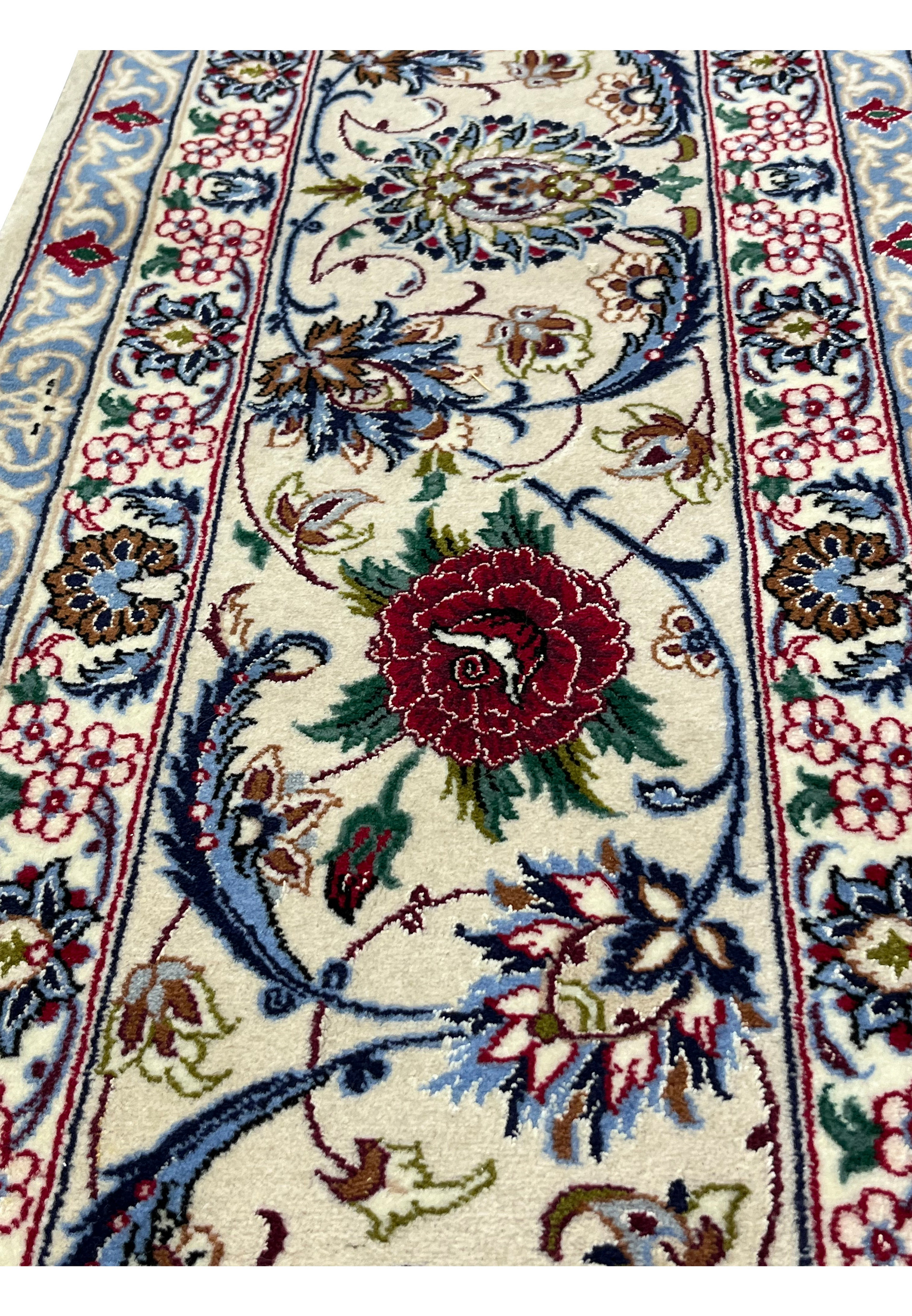 Zoomed border image of a Persian Isfahan rug showcasing crisp floral detailing, silk highlights, and a refined ivory and navy color balance