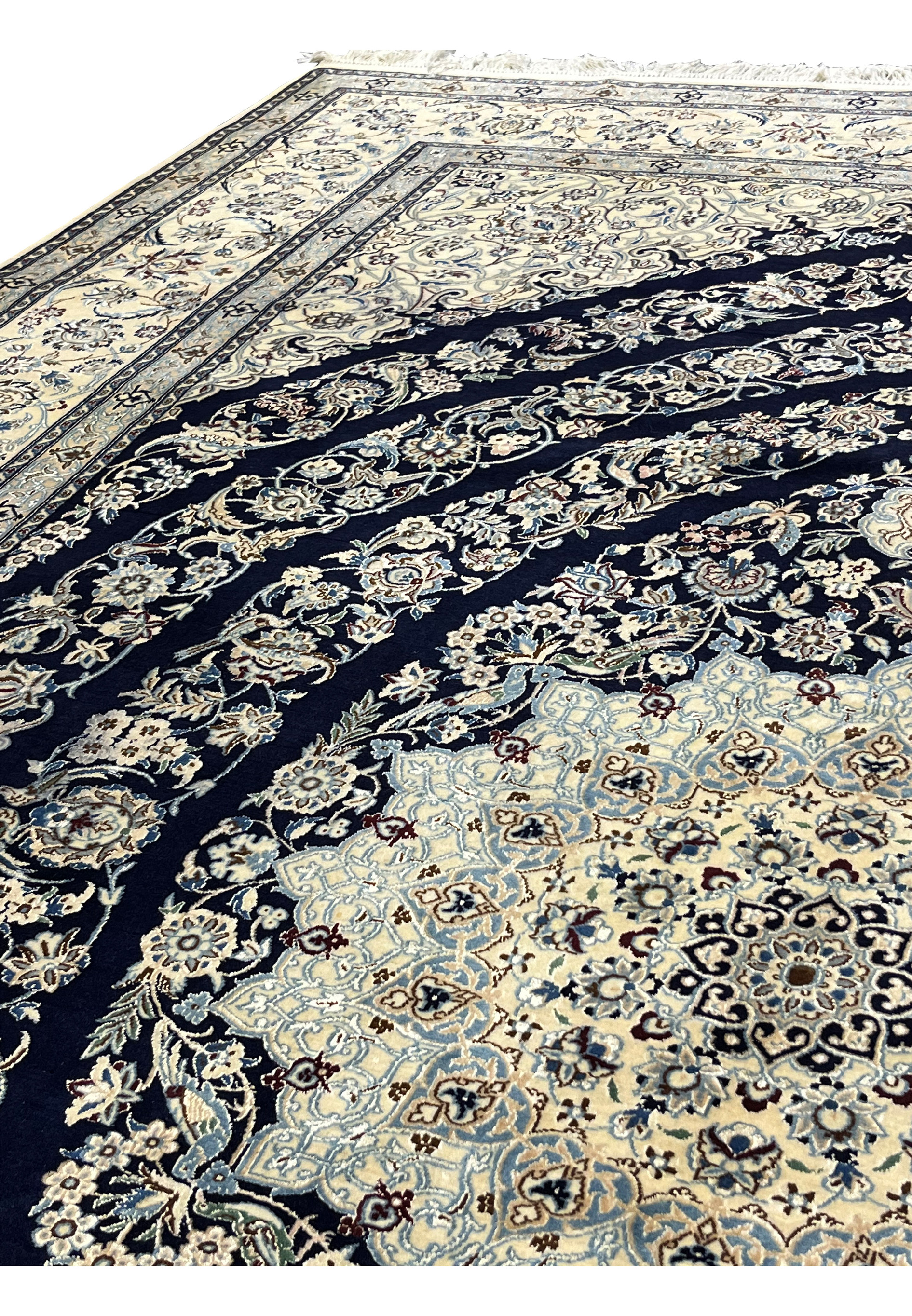 Floral motif detail from a Persian Nain 6 La rug with balanced vines and blossoms on a deep navy field
