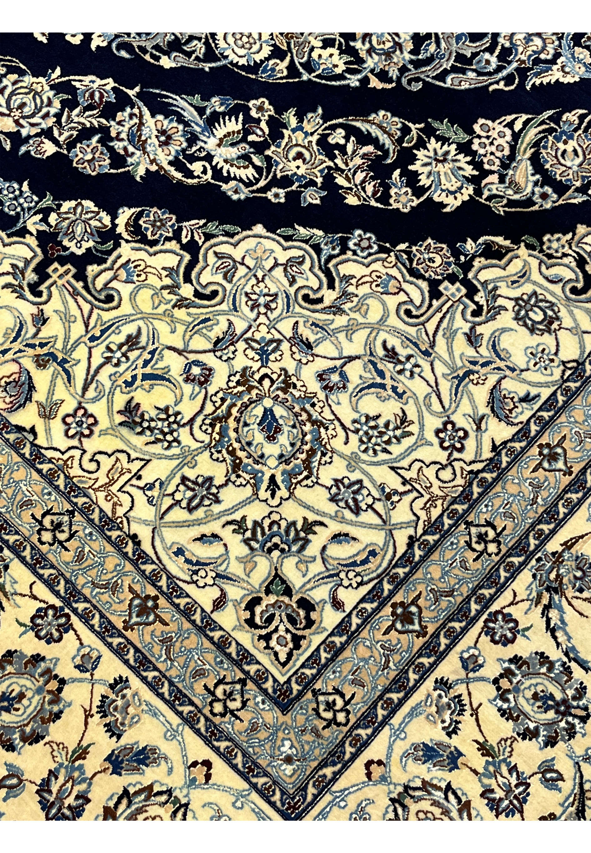 Inner edge detail of a Persian Nain 6 La rug showing ivory ground, fine floral scrollwork, and crisp silk outlines