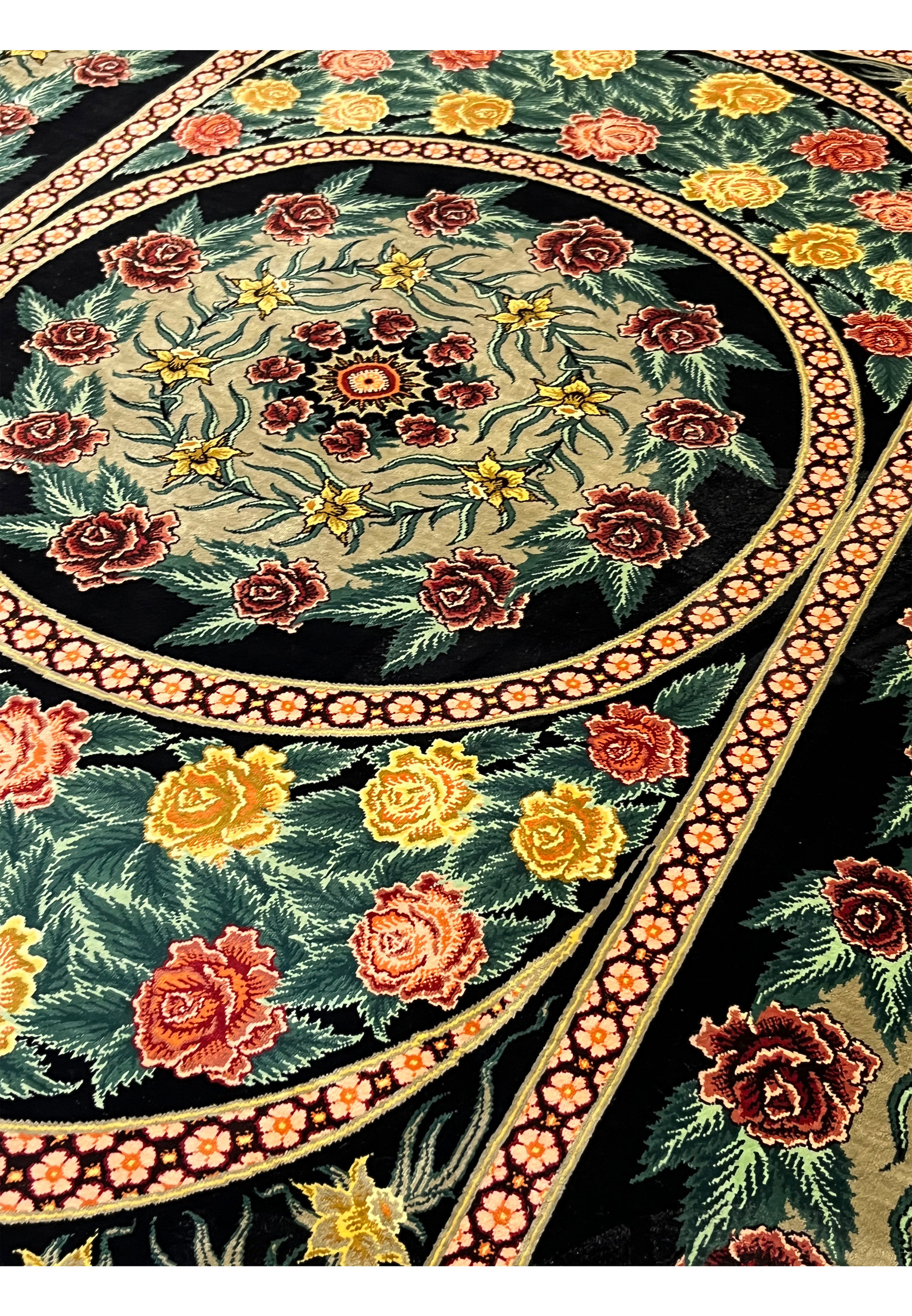 Angled view of a signed Persian Qum 100 percent silk rug highlighting natural silk sheen, fine knot density, and depth created by layered floral design
