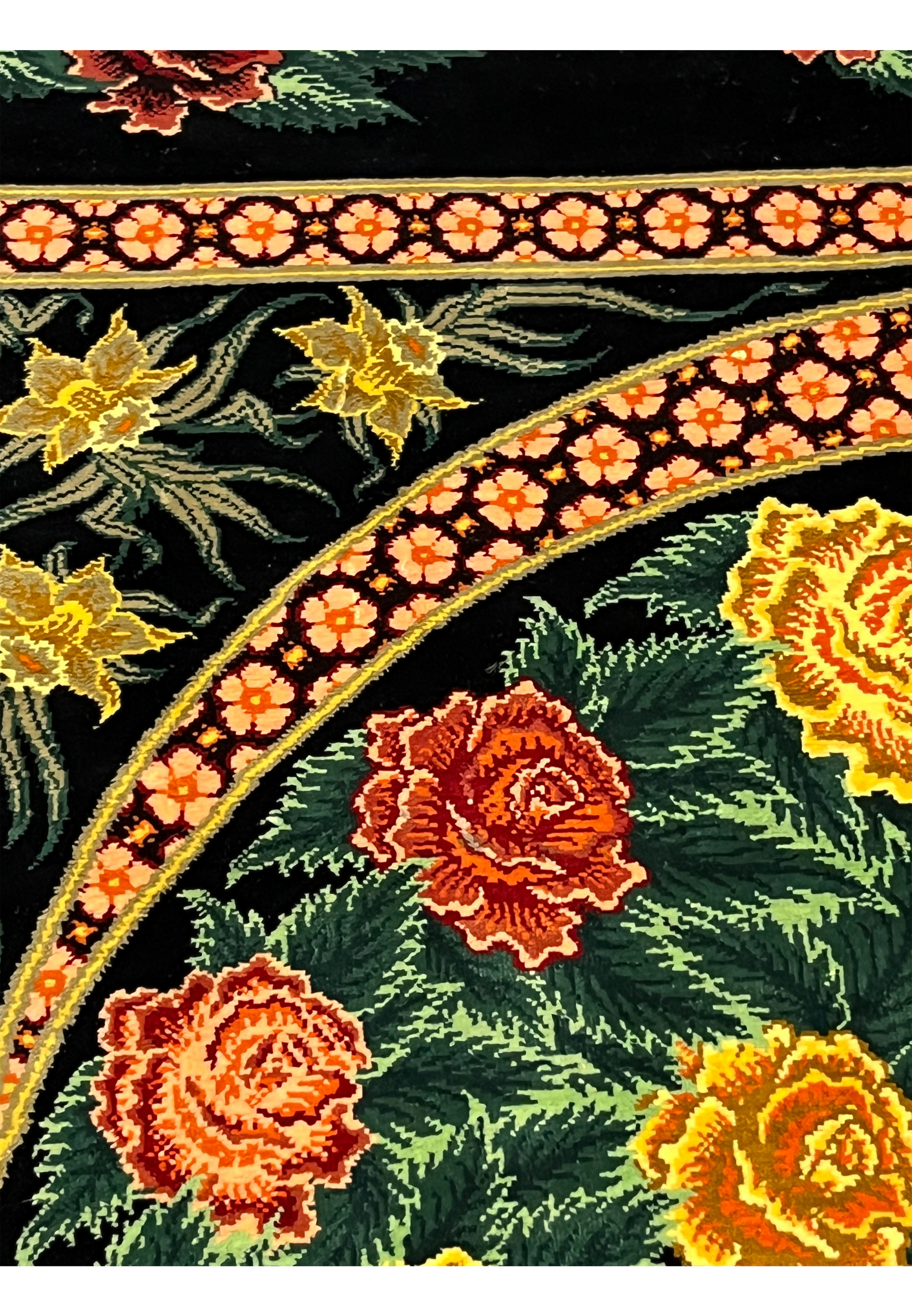 Floral motif close-up of a signed Persian Qum pure silk rug showing layered roses in red and gold tones against a black ground with crisp silk detail