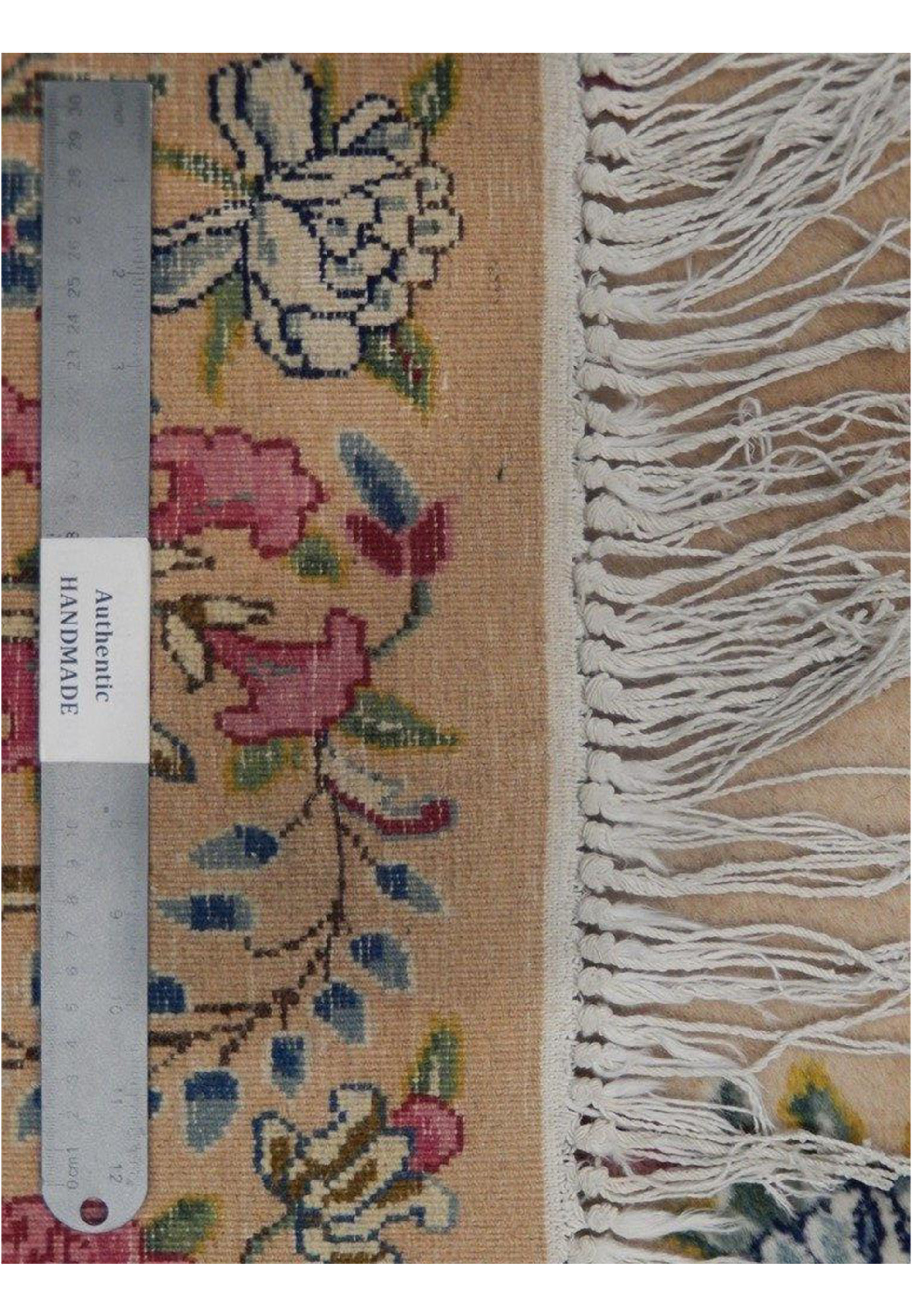 Backside view of a hand-knotted Persian Kerman rug showing tight knot structure, cotton foundation, fine weave, and neatly finished fringe ends