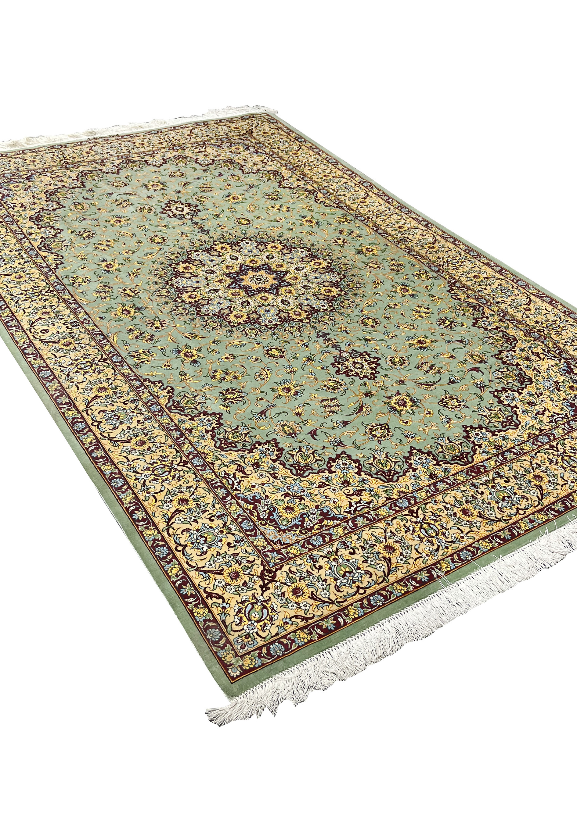 Angled perspective of a Mirmehdi Persian Qum silk rug emphasizing silk luster, sage green tones, floral medallion, and elegant proportions