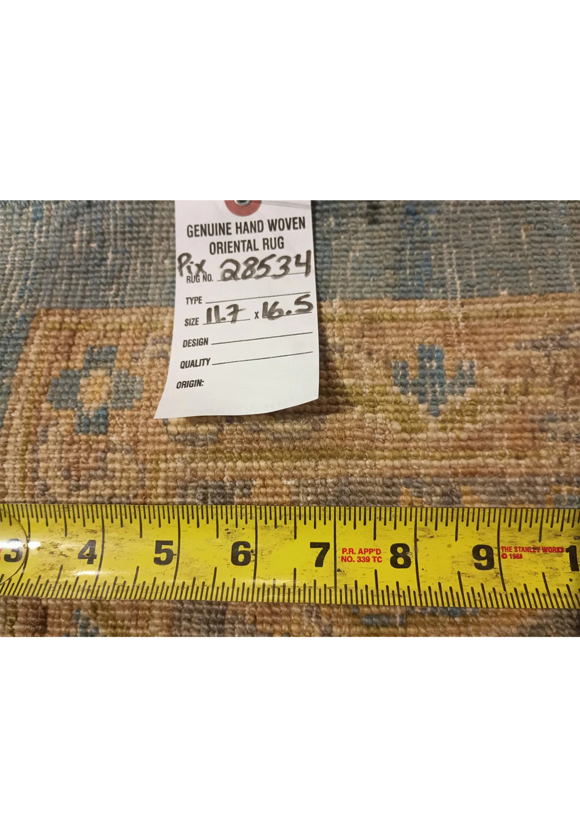 Backside of a hand knotted light blue Chobi Peshawar rug with ruler for scale, showing tight knot structure, wool foundation, and precise craftsmanship