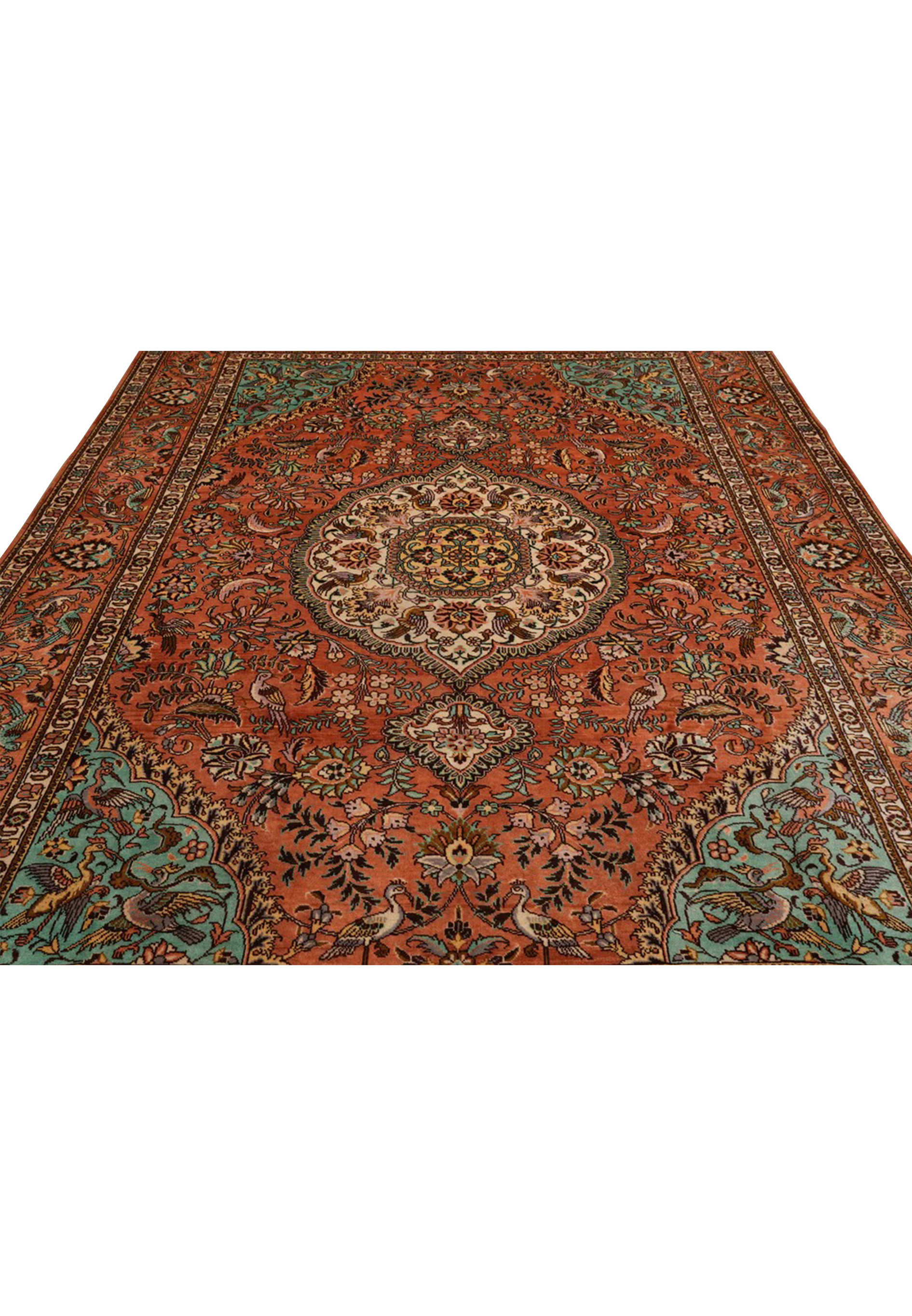 Midfield detail of a signed Paradies Persian Tabriz rug featuring birds among flowering branches on a warm terracotta background