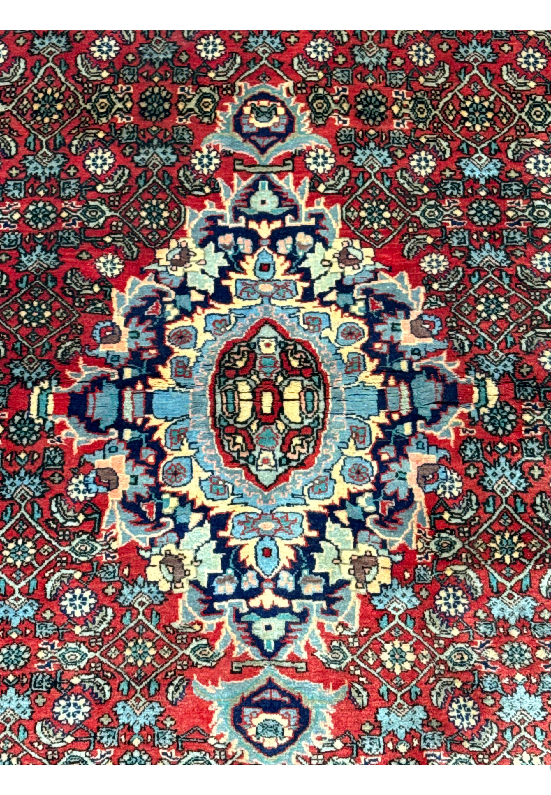 Close-up of the floral rosette medallion in a Persian Sarough rug highlighting light blue, ivory, navy detailing, and crisp hand-knotted definition
