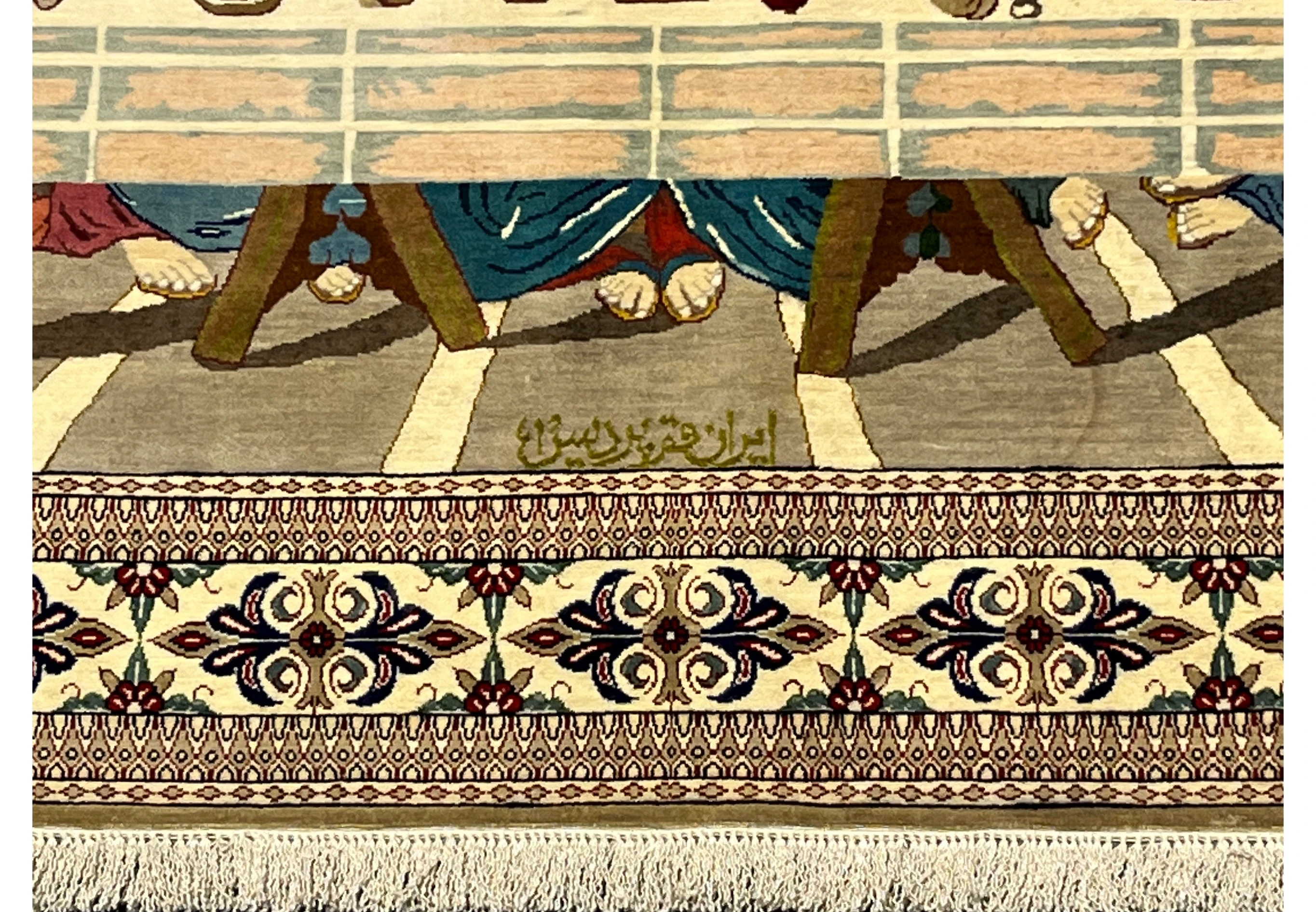 Lower section of signed Persian Qum silk pictorial rug showing Persian signature, detailed floor patterns, and refined border elements