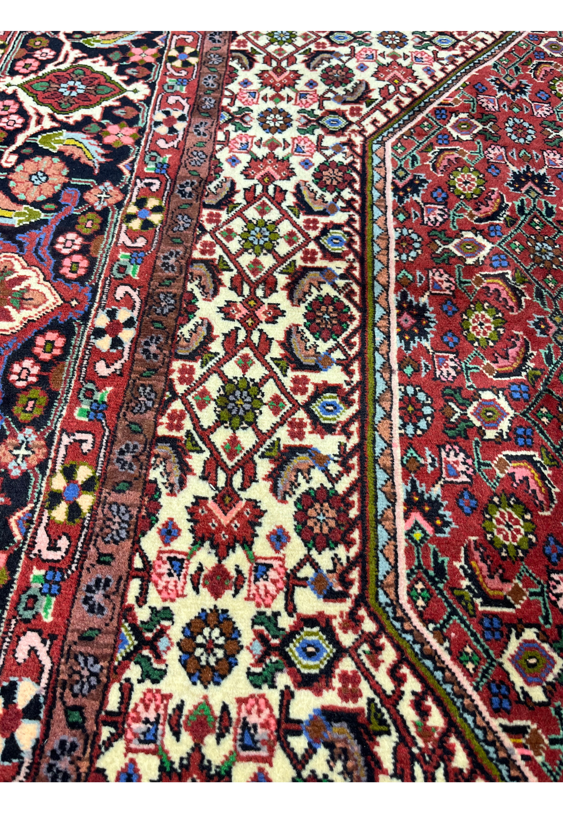 Close-up of repeating geometric motifs in a Persian Bijar rug highlighting intricate wool knotting, sharp pattern clarity, and rich traditional colors