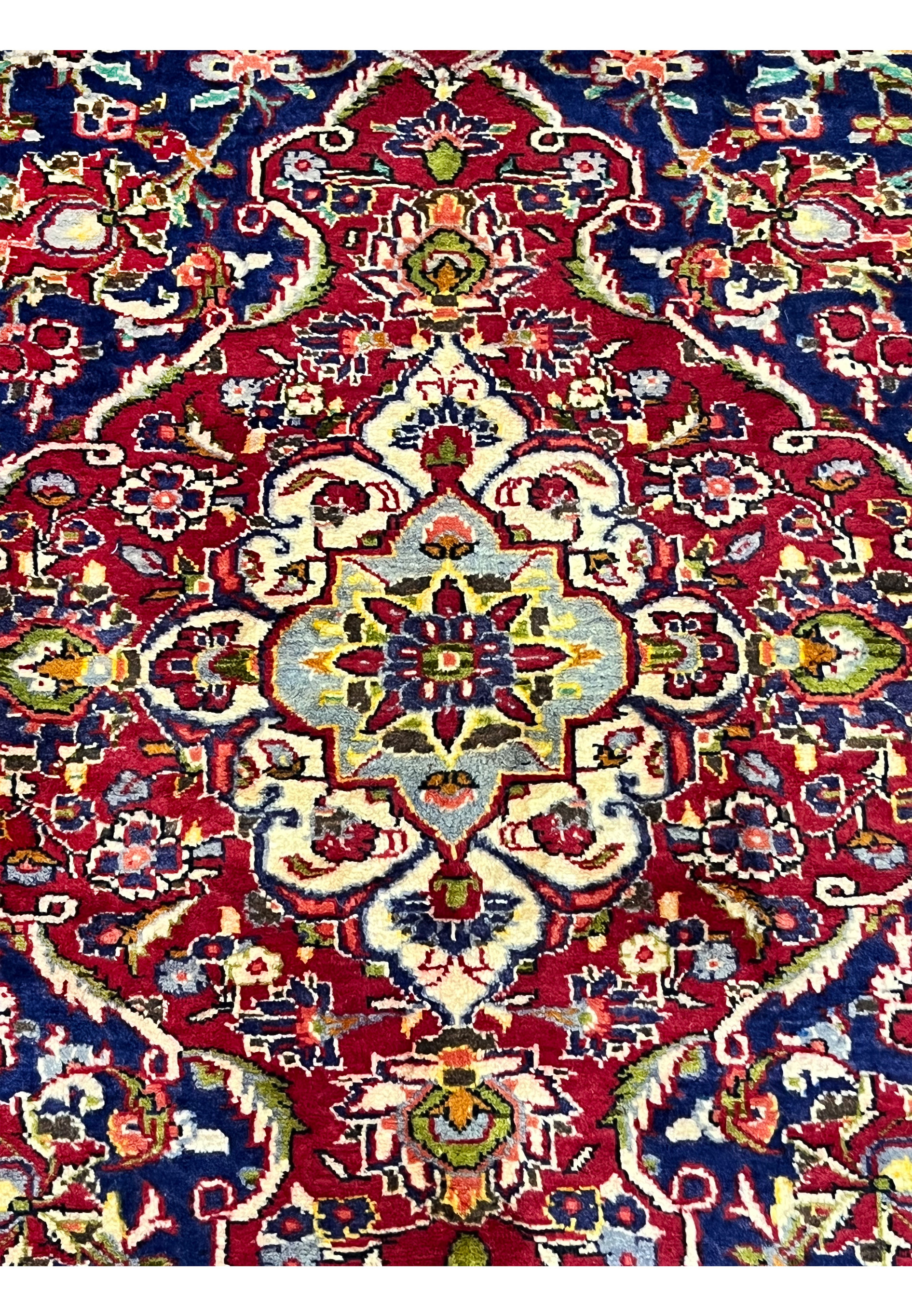 Zoomed medallion detail of Persian Isfahan rug revealing fine knot density, precise floral drawing, and elegant color transitions