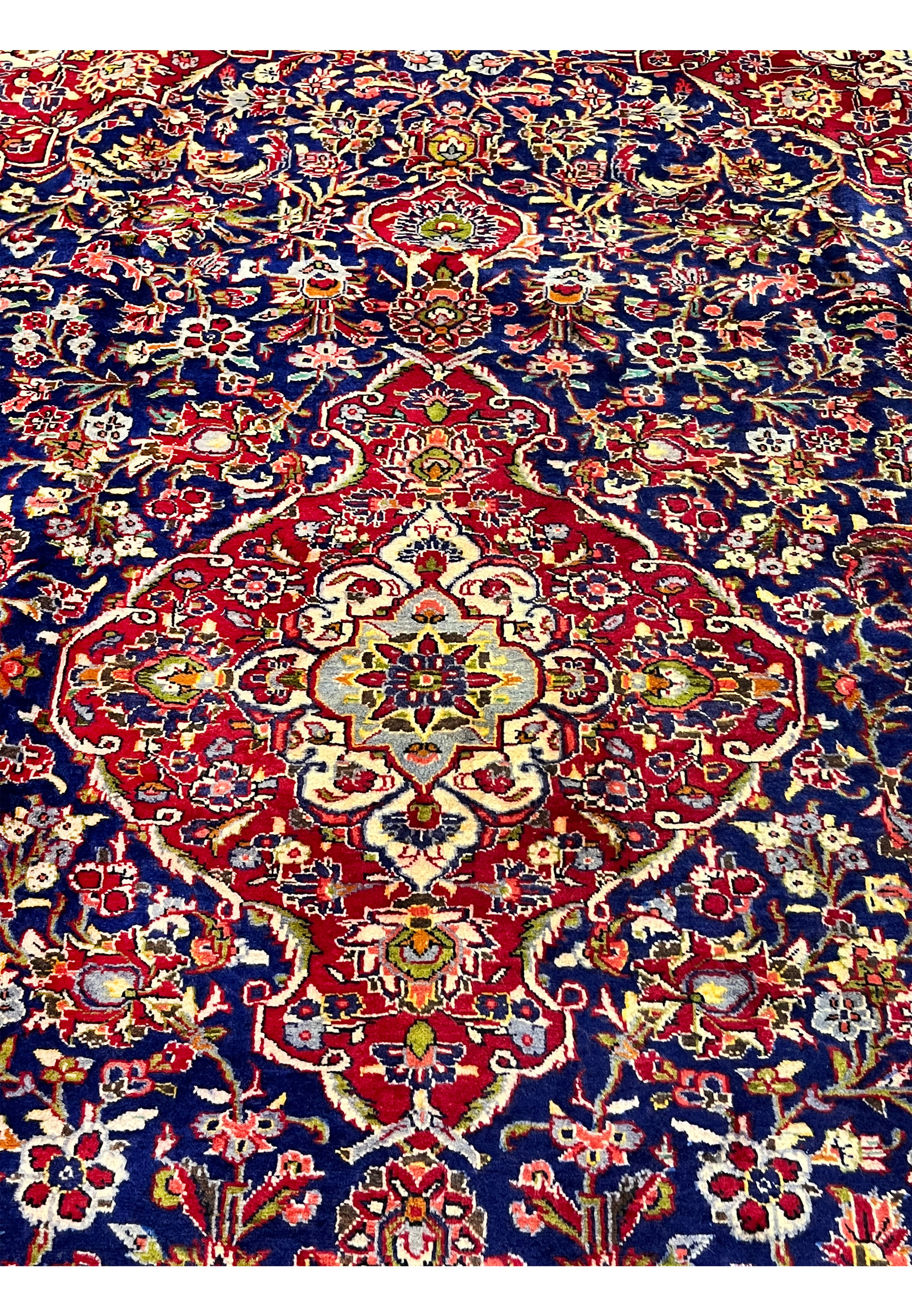 Central medallion view of Persian Isfahan rug with layered brick red, ivory, light blue, and gold floral detailing in classic court style