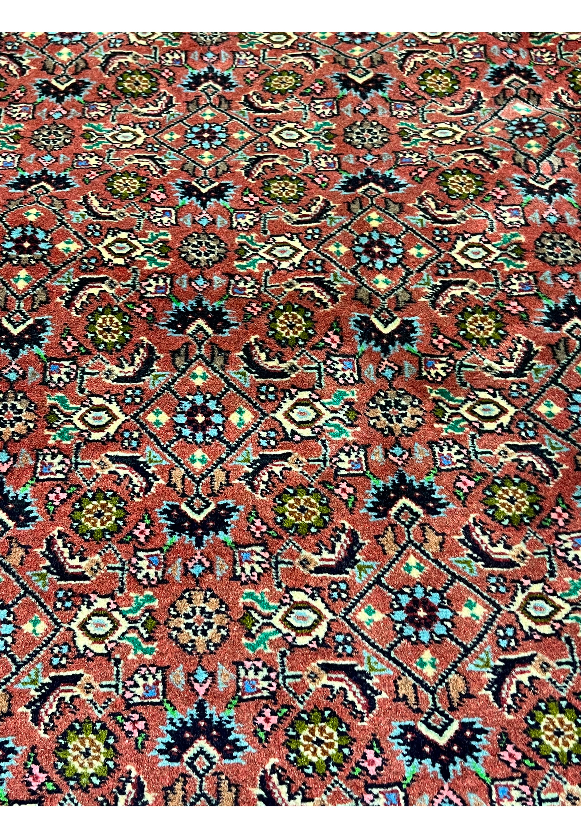 Close-up of Persian Bijar rug motifs featuring stylized flowers, diamond shapes, and classic craftsmanship