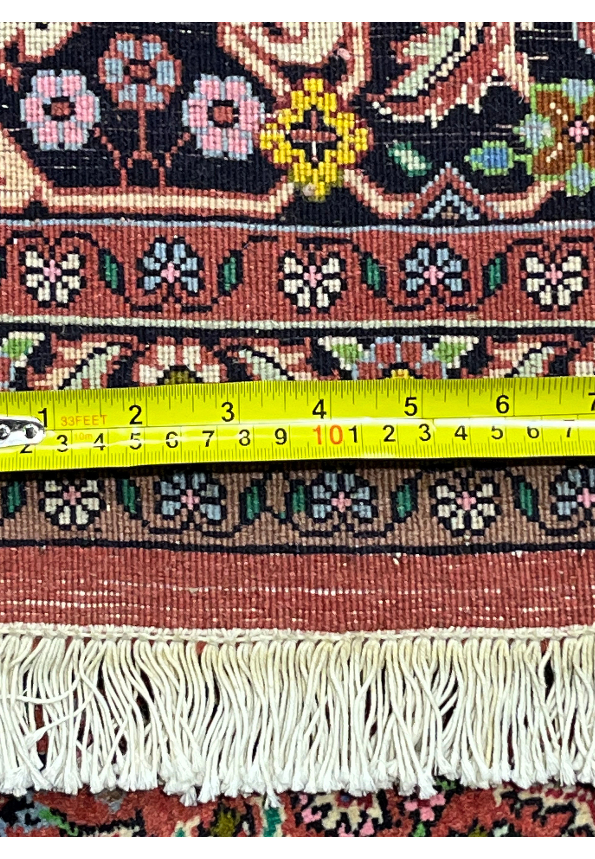 Back of Persian Bijar rug with yellow tape measure showing fine knot density and tightly woven construction